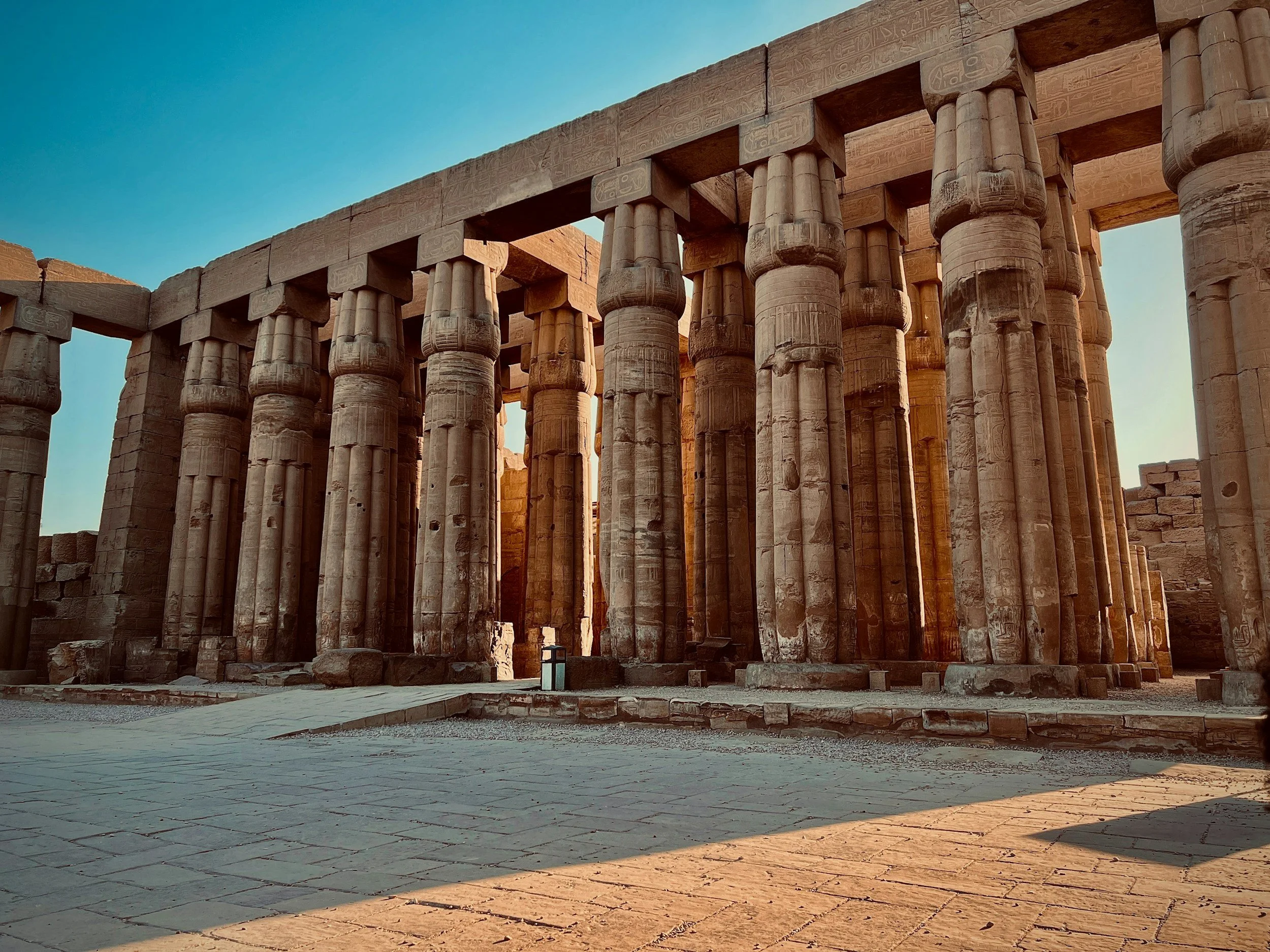 The columns of the Great Hypostyle Hall at Karnak Temple, Luxor, against a blue sky