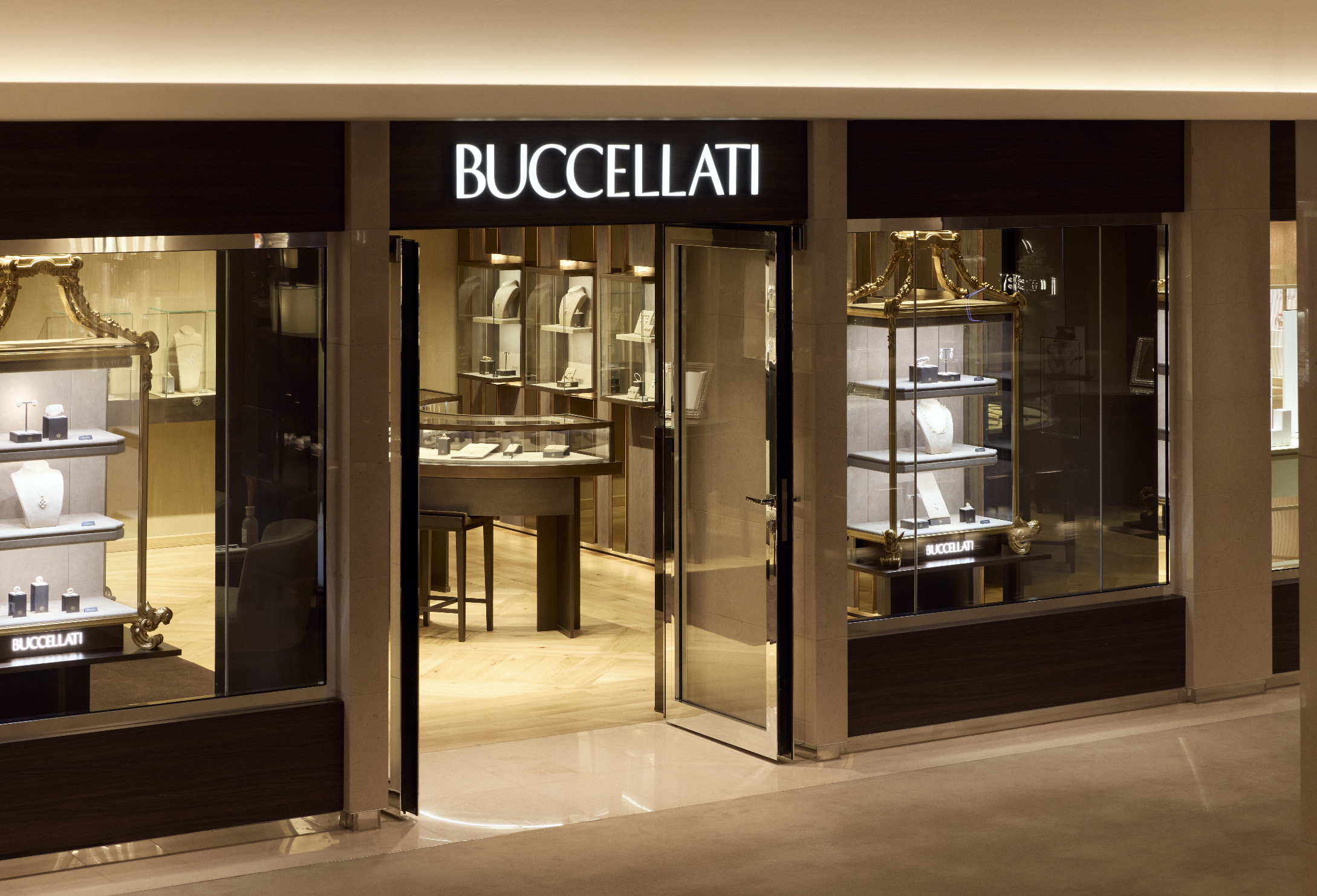 Storefront of Buccellati jewelry store with glass display windows showcasing jewelry and gold jewelry displays inside.