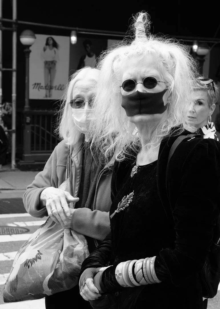 These woman were this white, ghostly. Pedestrians walked around them, keeping their distance from these wraiths.