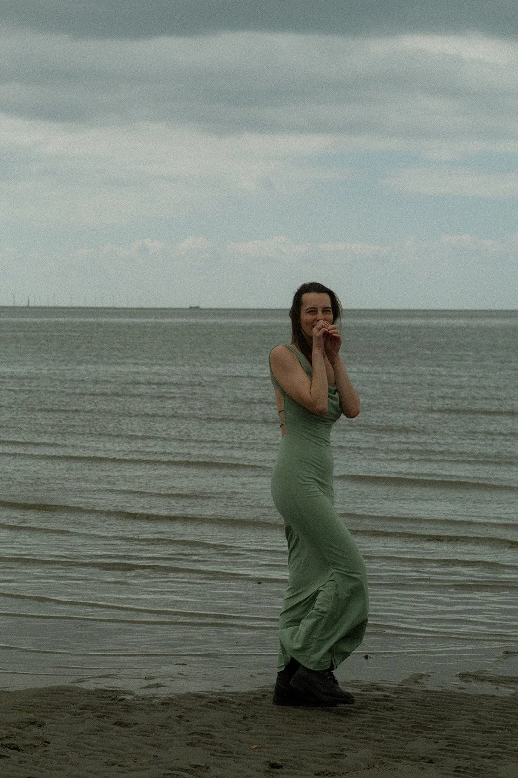 Vrouw aan zee tijdens een moment van bewustzijn en zelfreflectie. Persoonlijke ontwikkeling, vitaliteit en innerlijke rust.