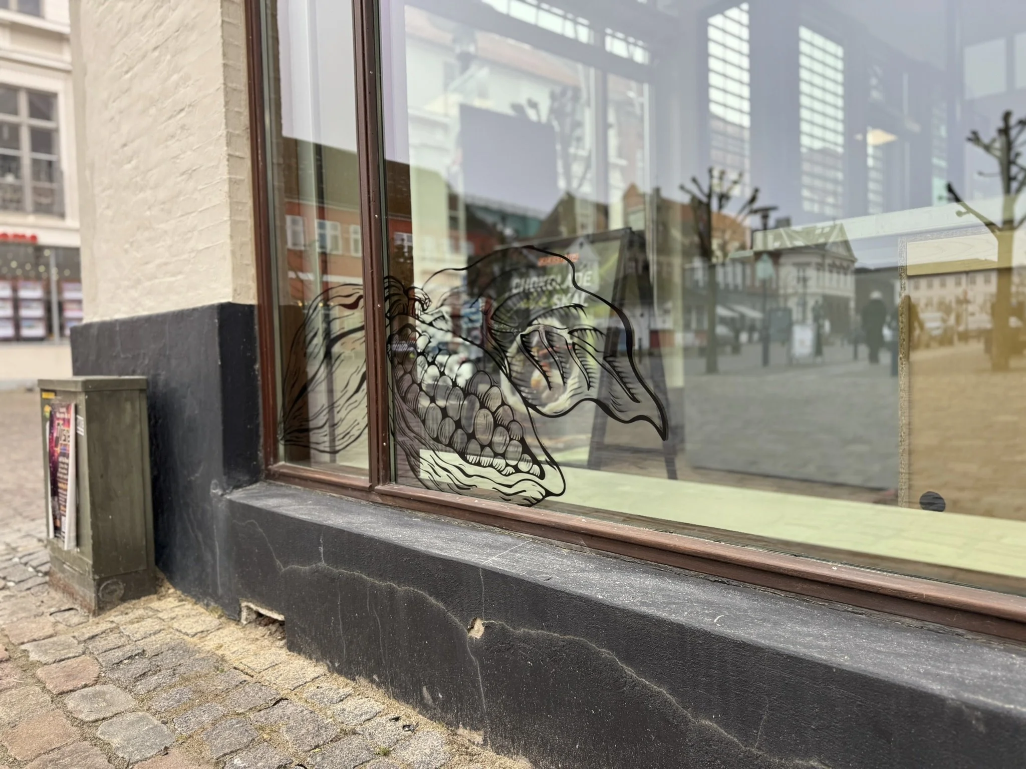 Dekorativ folie med grafik på butiksvindue i gågaden