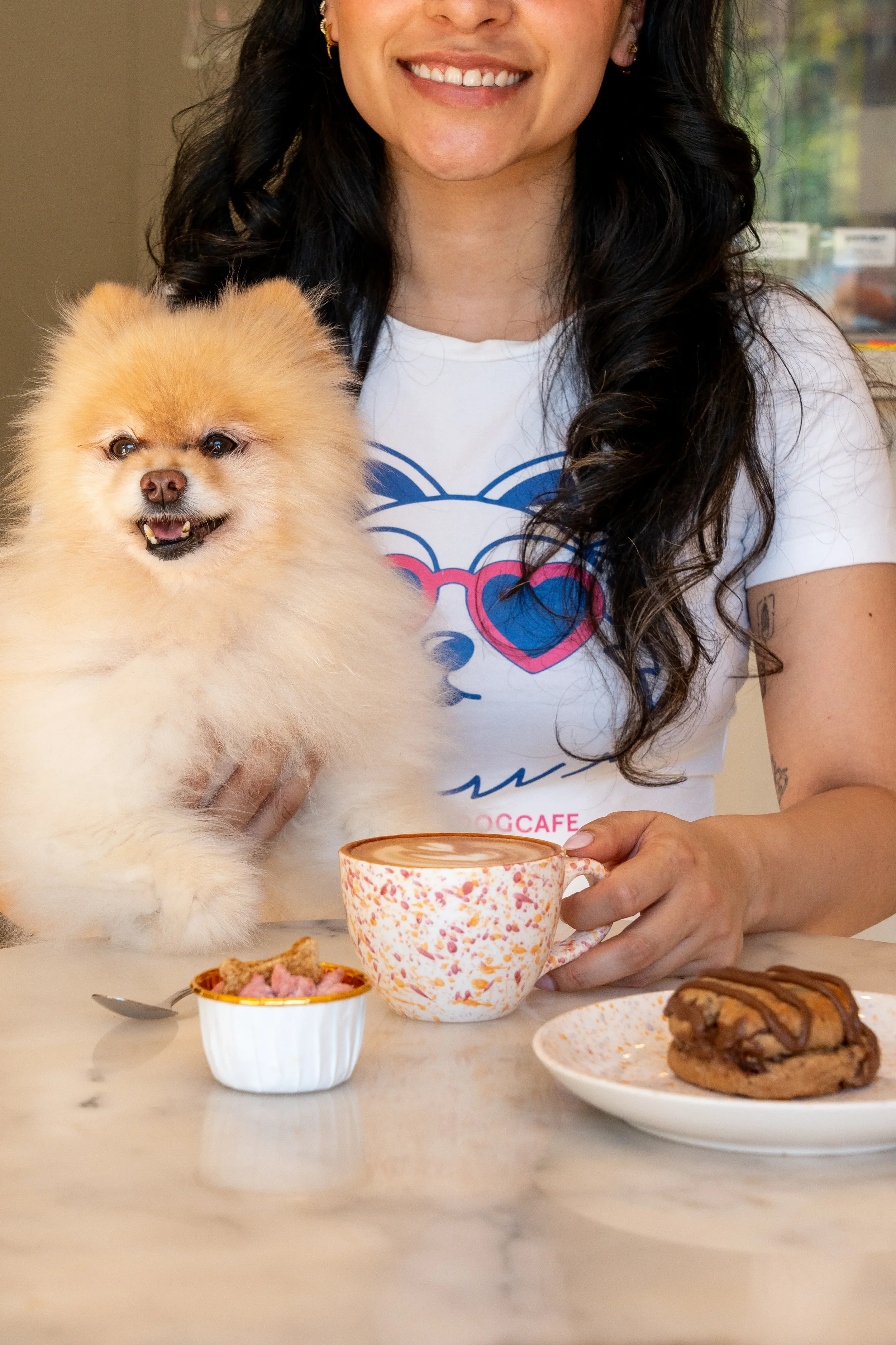 Dueña y su pomerania disfrutando de un café con leche y chuches artesanales en Perrísimo, el espacio pet-friendly de Menéndez Pelayo junto al Parque del Retiro, Madrid