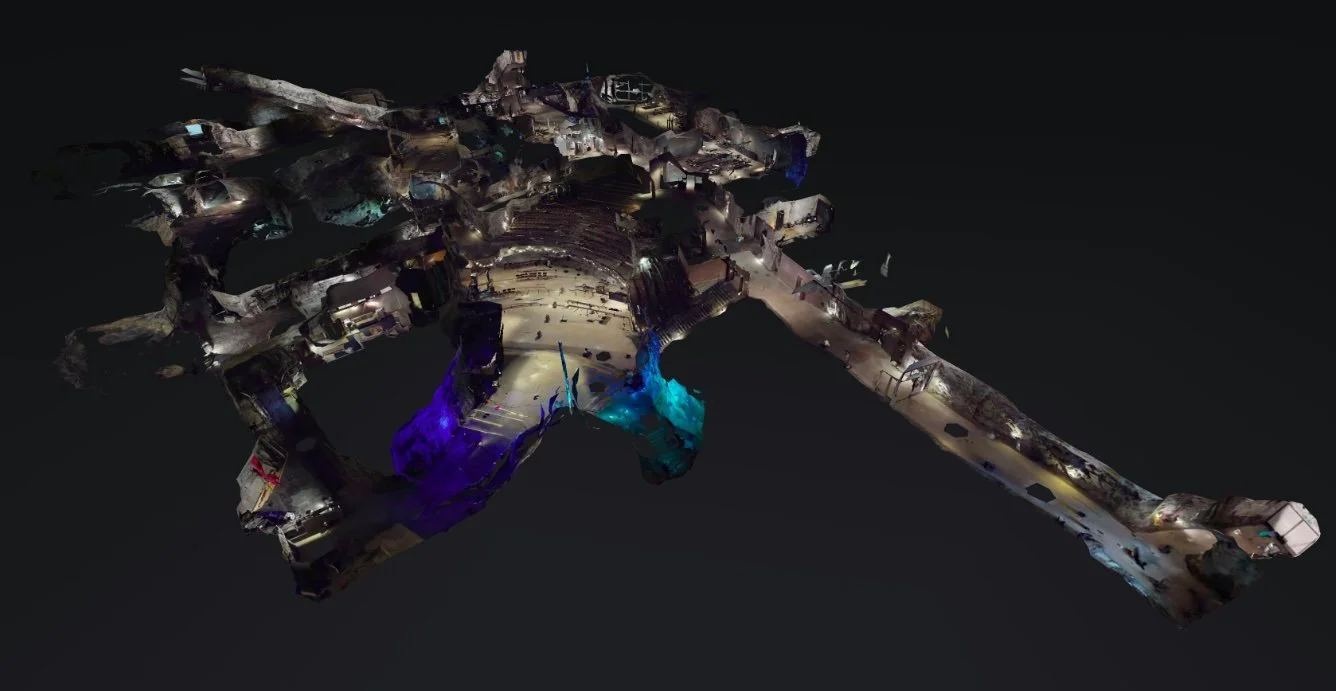 3D rendering of a complex underground cave system, featuring illuminated passages and chambers with colorful lighting in shades of blue and purple.