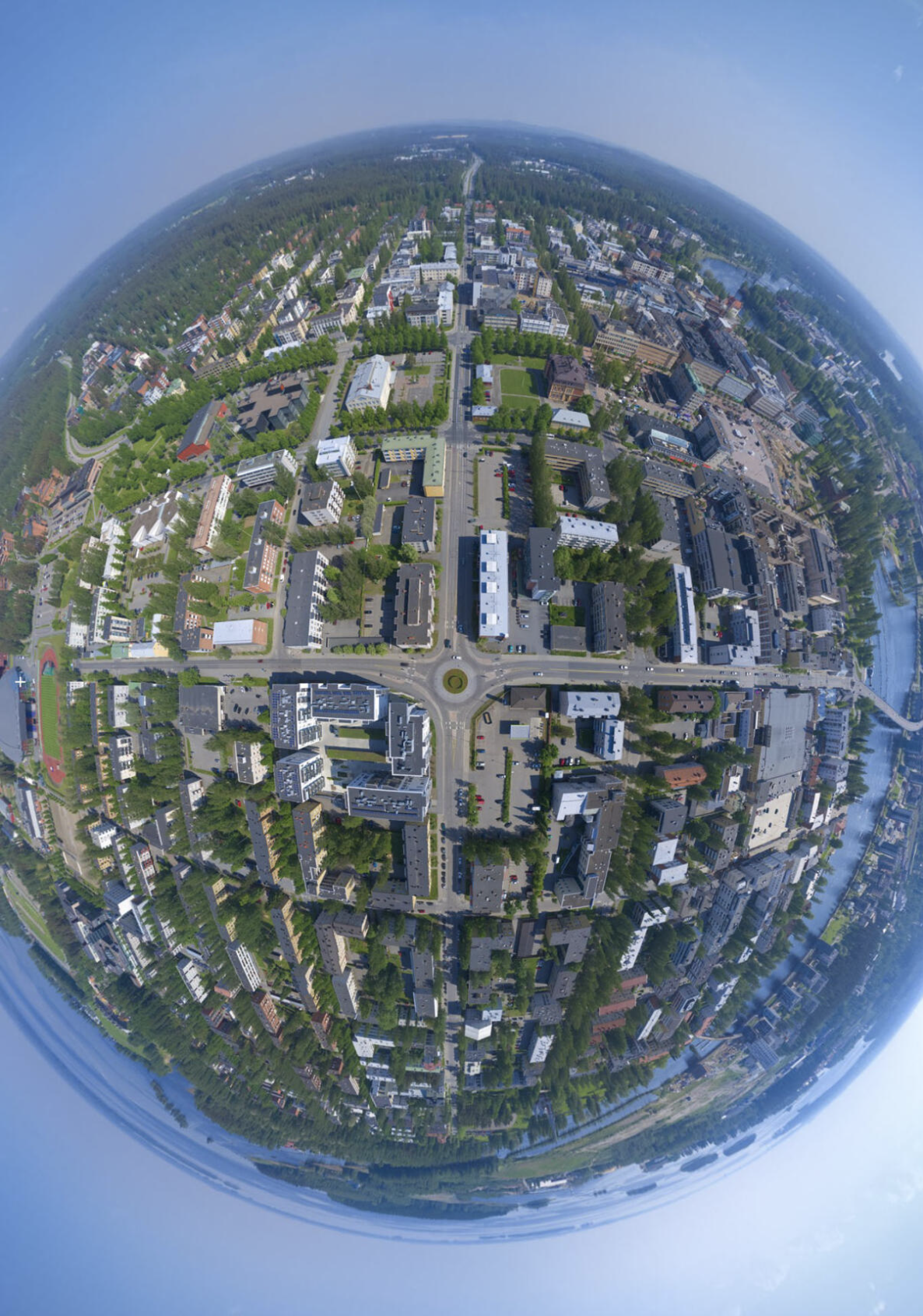 Aerial panoramic view of a city with buildings, roads, and greenery creating a globe-like effect.