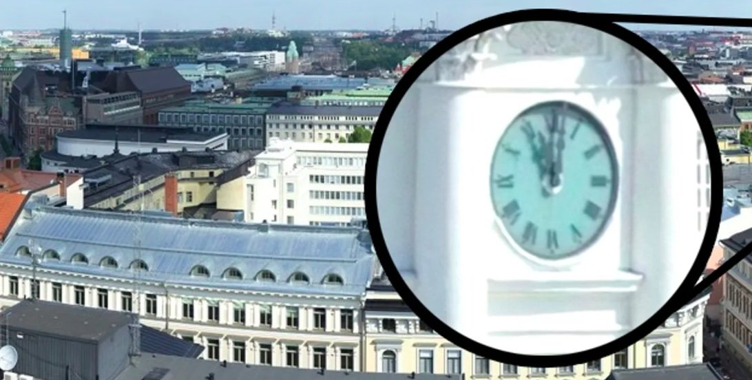 Aerial cityscape view with a close-up of a clock tower showing the time at 8:42.