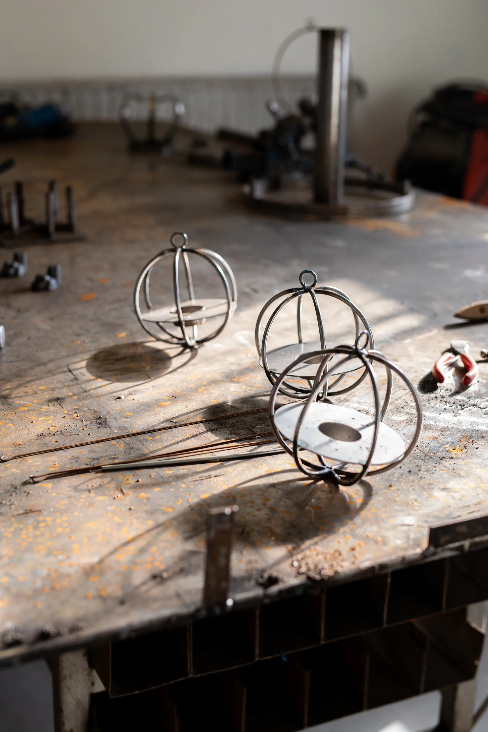 Metal decorative ornaments on a workbench in a workshop.