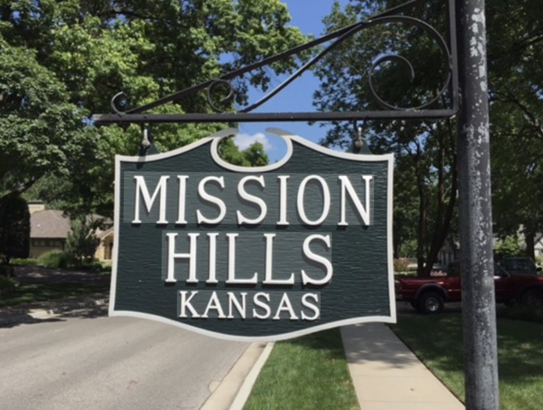 A Green and white sign showing Mission Hills Kansas
