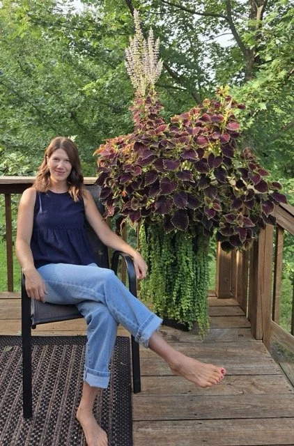 Woman sitting on chair enfront of a beautiful plant design
