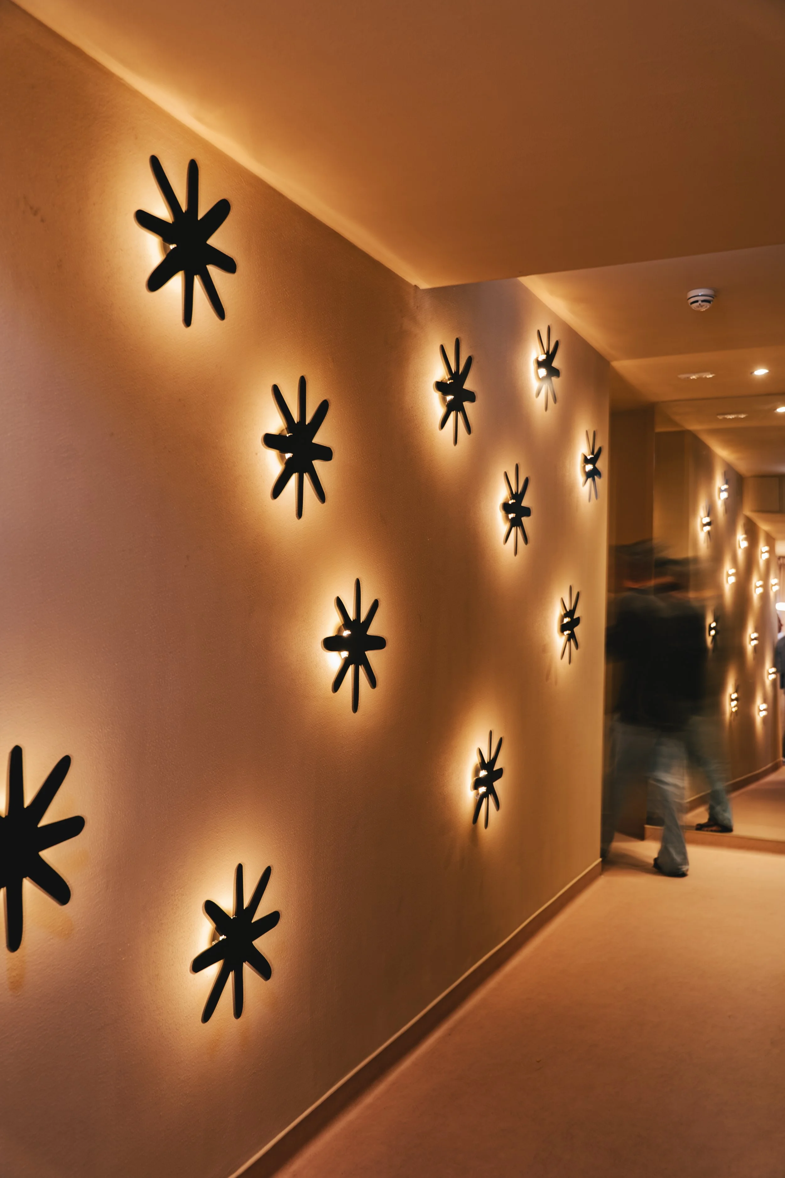 Corridor with illuminated star wall lights at Reset Society, Lisbon