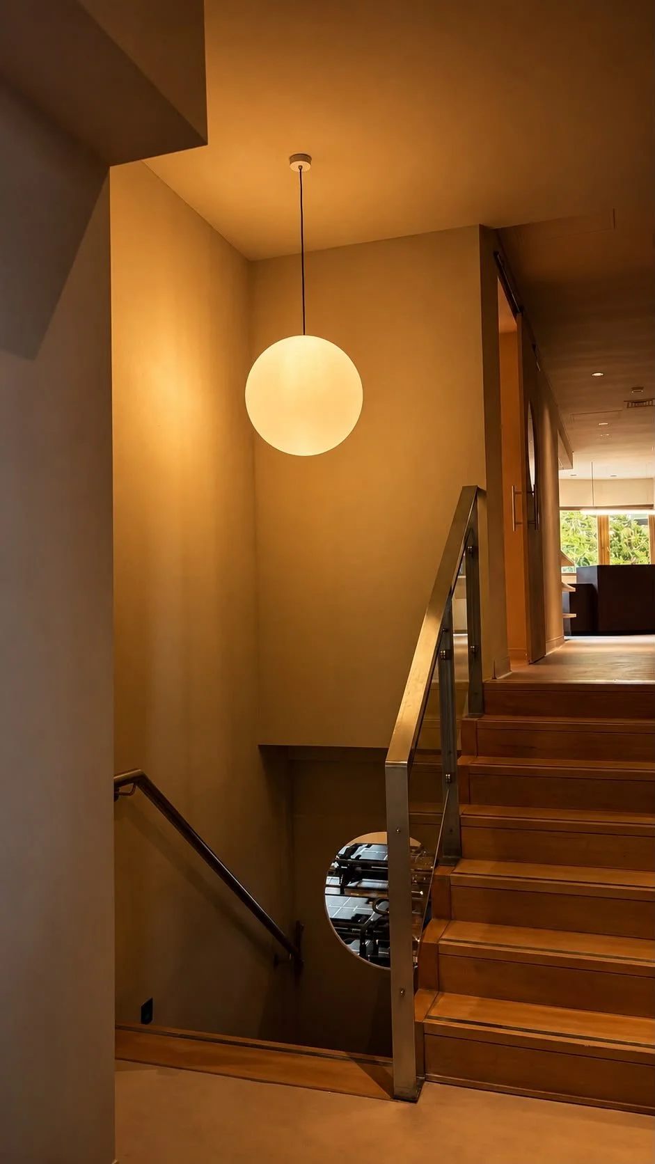Staircase with a globe pendant light inside the studio