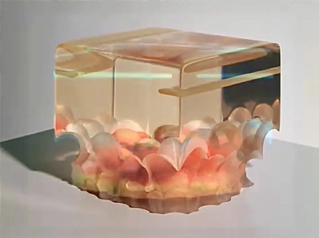 A transparent box filled with colorful, translucent balls, placed on a white surface with soft lighting.