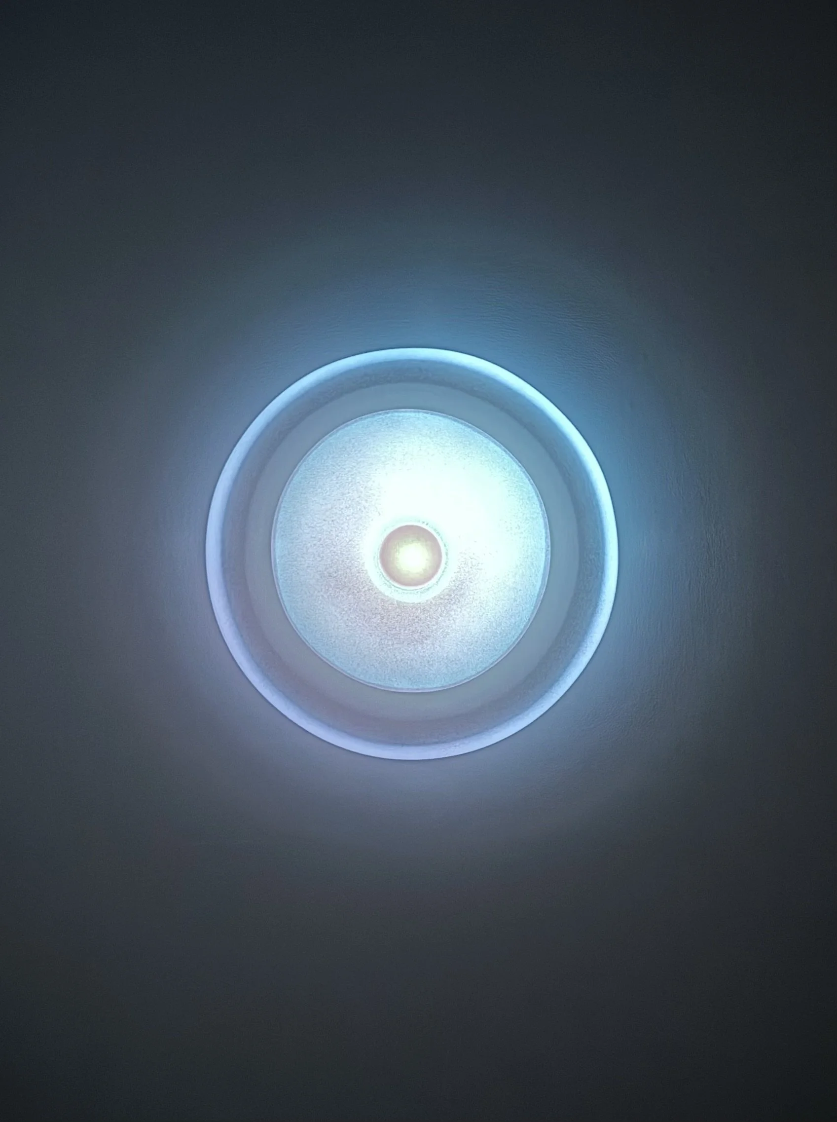 Ceiling light fixture emitting a blue glow with concentric circles
