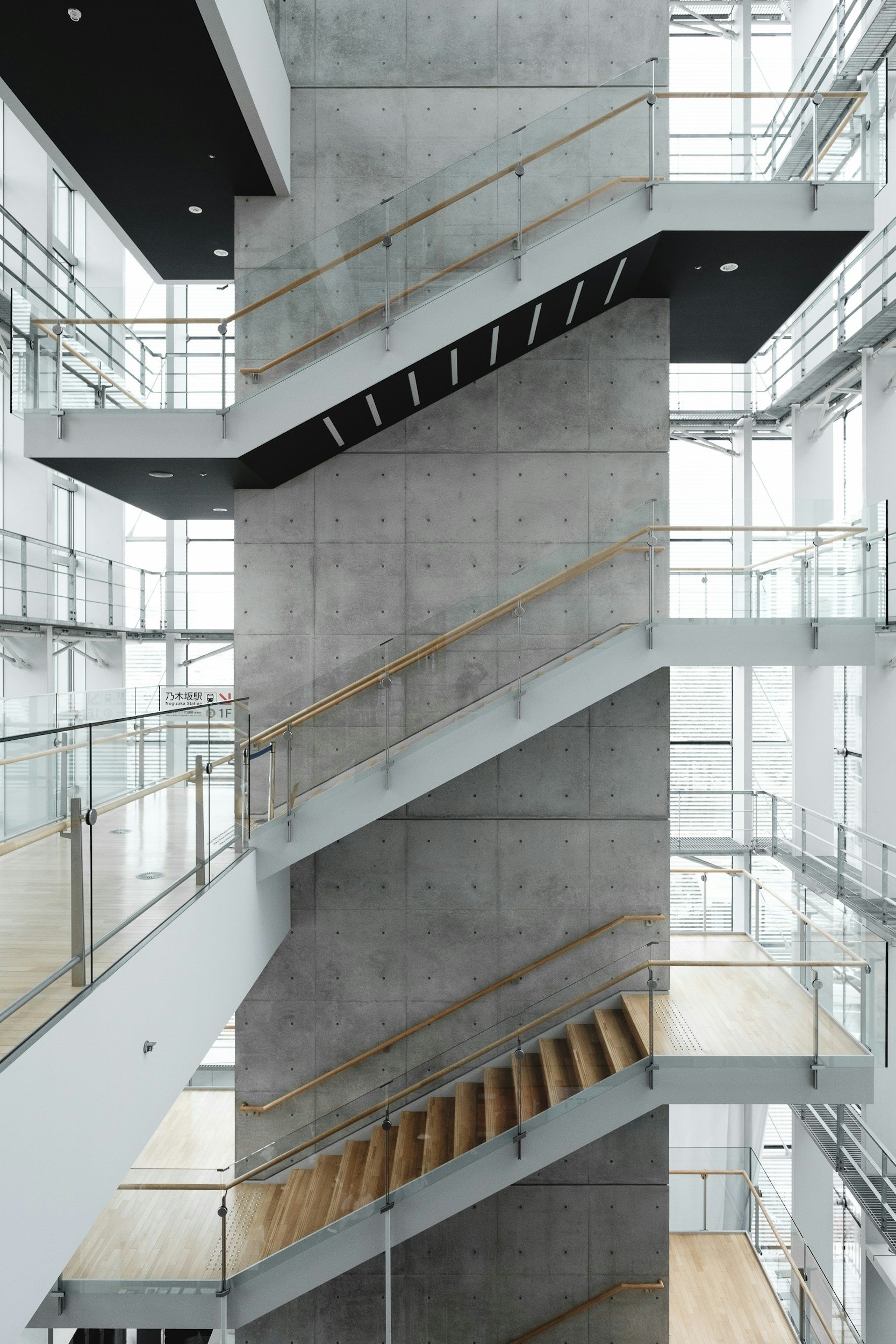 Multiple floors with stairs and glass railings in a modern building interior.
