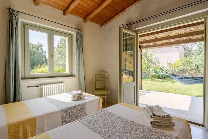 Camera ampia e luminosa del cottage ginepro con affaccio sul giardino con amaca