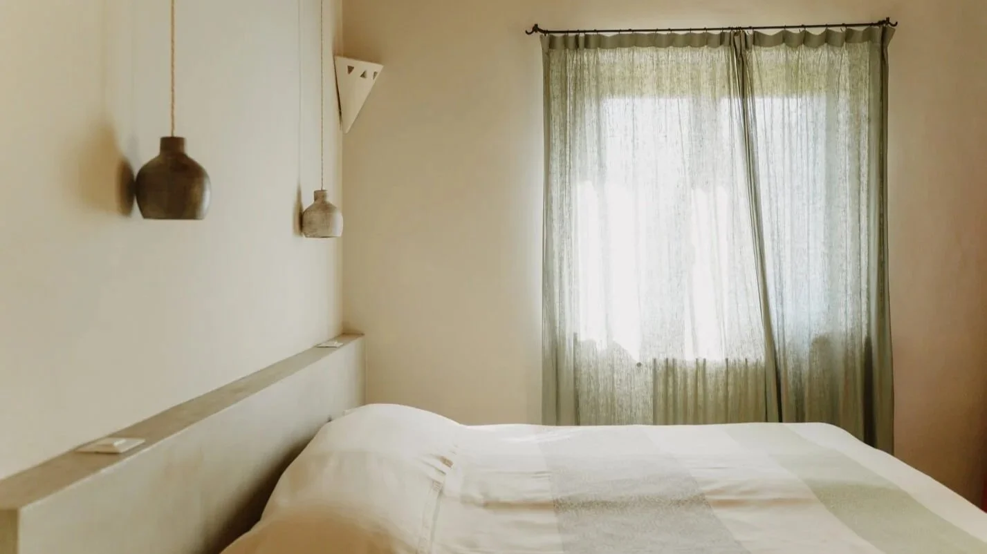 Camera Asfodelo decorata con letto matrimoniale in colori tenui