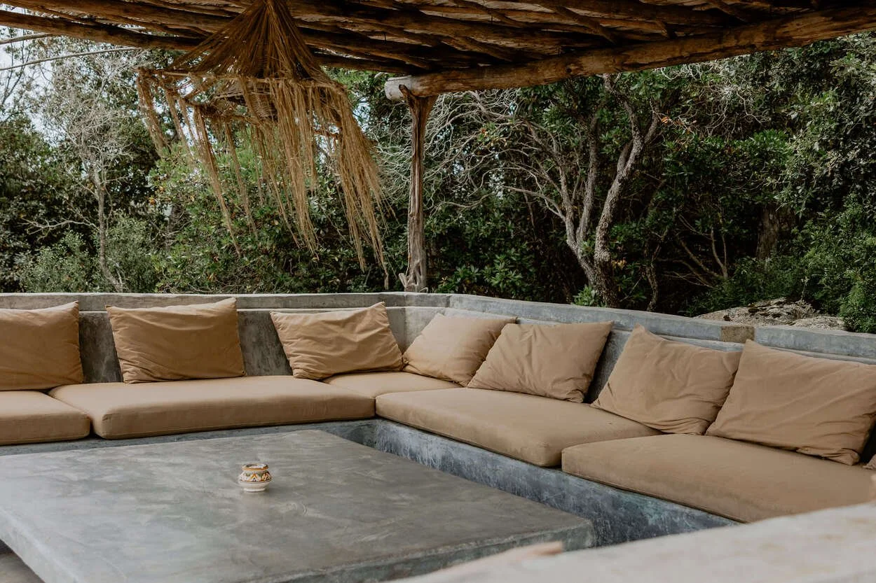 Piscina di Mascaratu con tendalino in vimini e sdraio in muratura vista colline rocciose