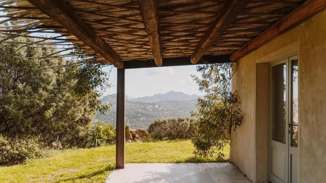 Veranda del cottage Asfodelo con affaccio sul prato verde e la vista delle colline