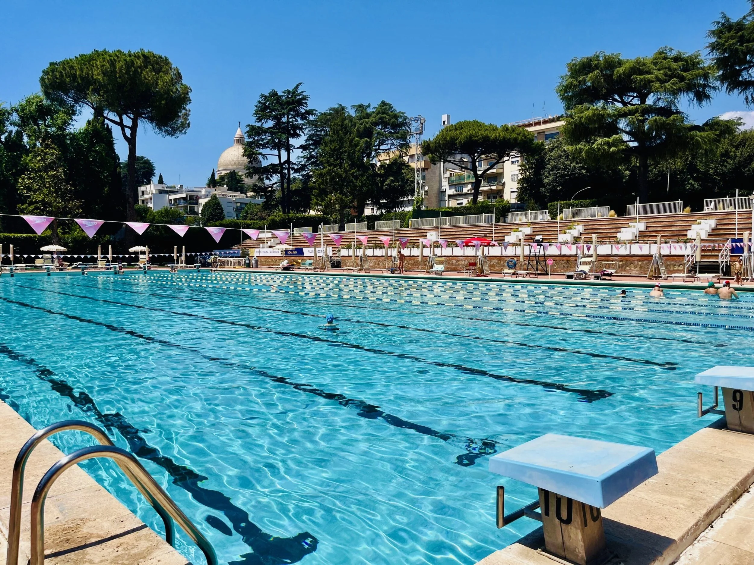 Olympic-size outdoor pool with lane ropes and starting blocks at Piscina delle Rose in EUR, Rome