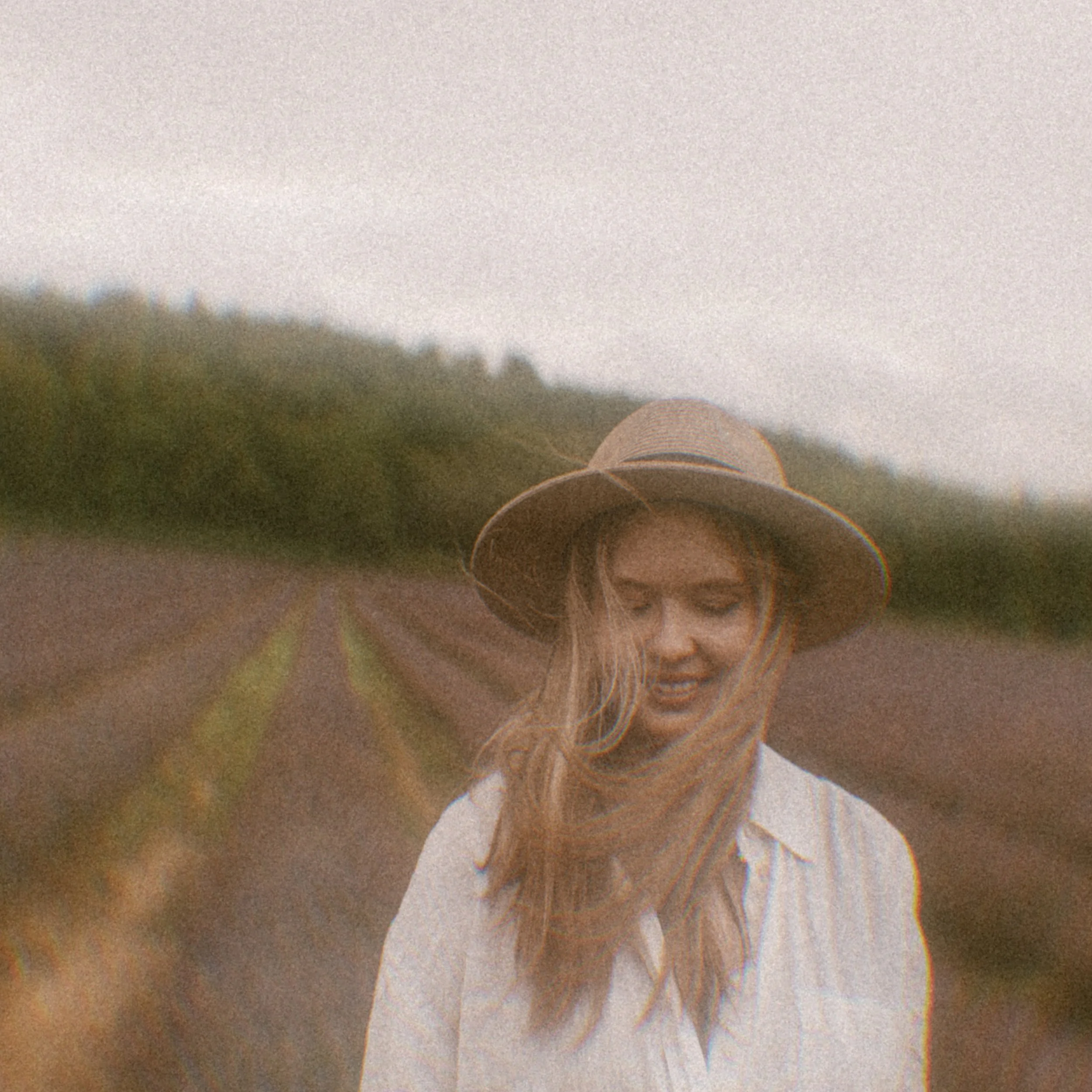Close-up of a person's eye with multiple camera or lens reflections and a background of blurred trees. Ekaterina Pytina