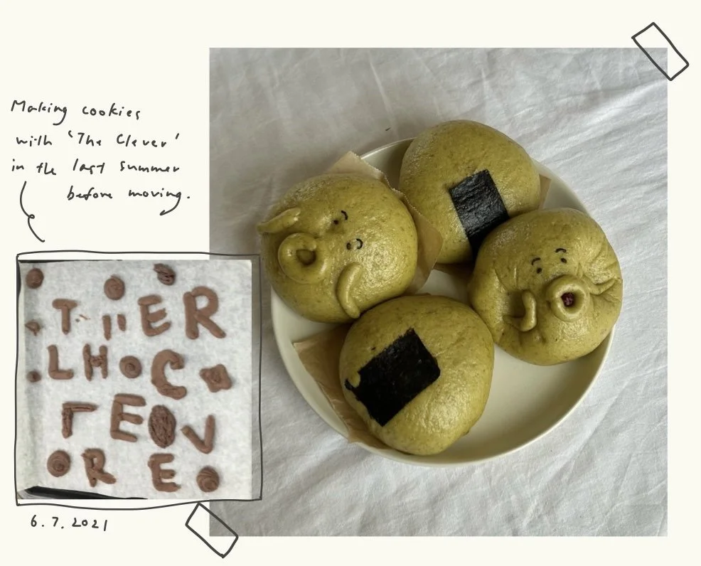 Plate of four yellow Asian steamed buns with faces and black seaweed decorations, including a pig, a face with cheeks, and a face blowing a kiss, on a white surface, with a handwritten note about making cookies with a character named 'The Clever' in the last summer before moving, and a close-up of letter-shaped cookies spelling 'TIER LMOCC EOV REY'.