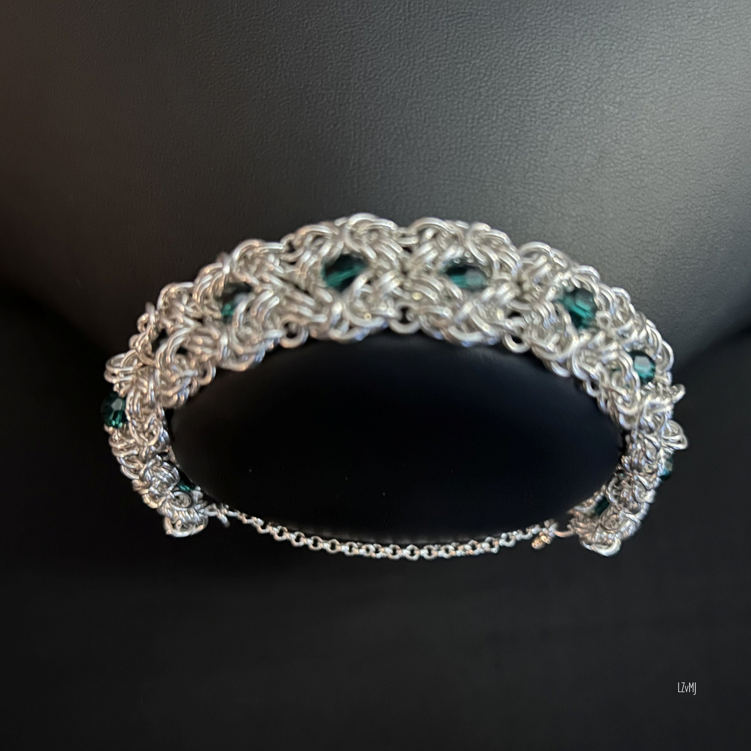 Bracelet on display bust, highlighting the sterling rosettes and green crystal glow
