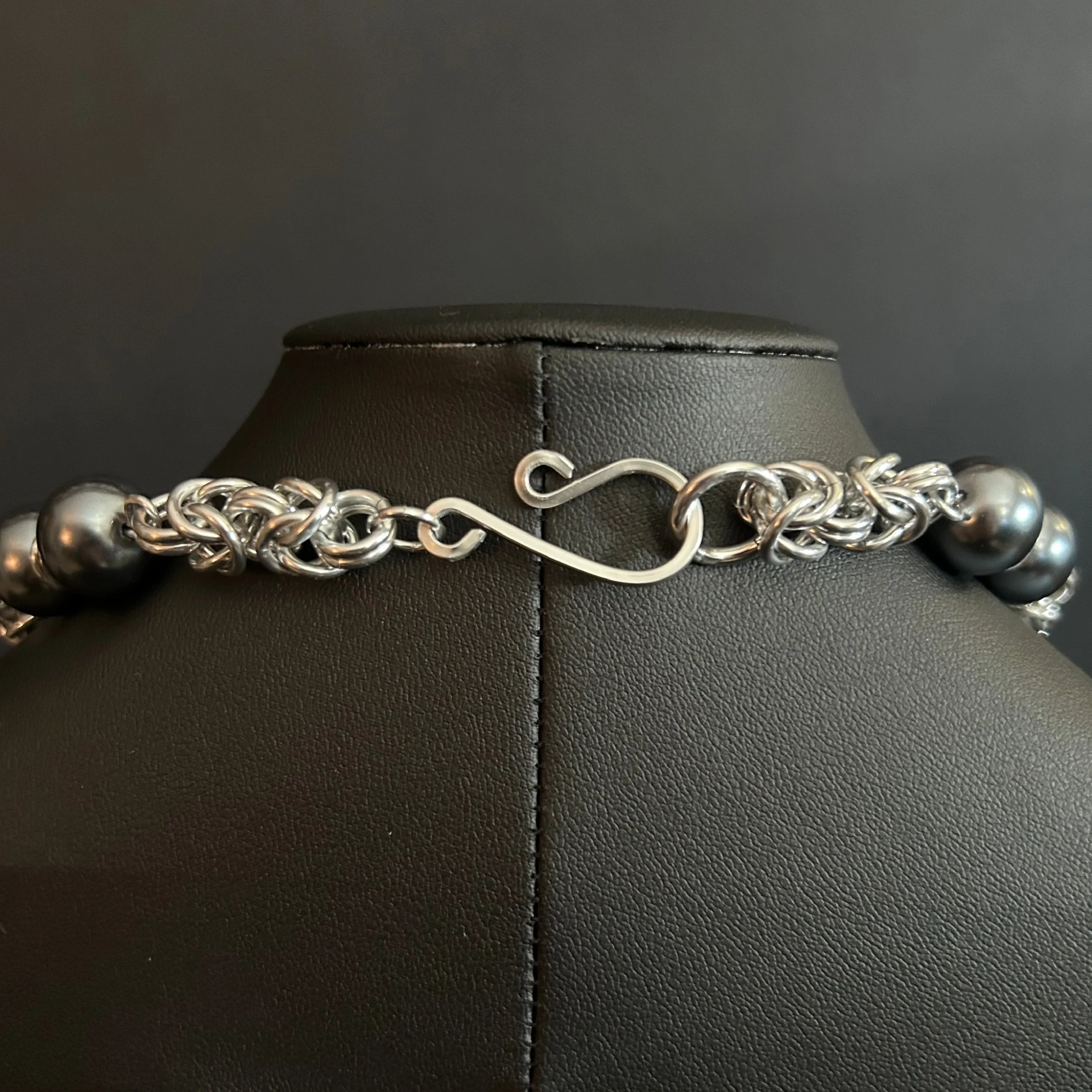 “Close-up of the handmade clasp and connecting aluminum rings.”