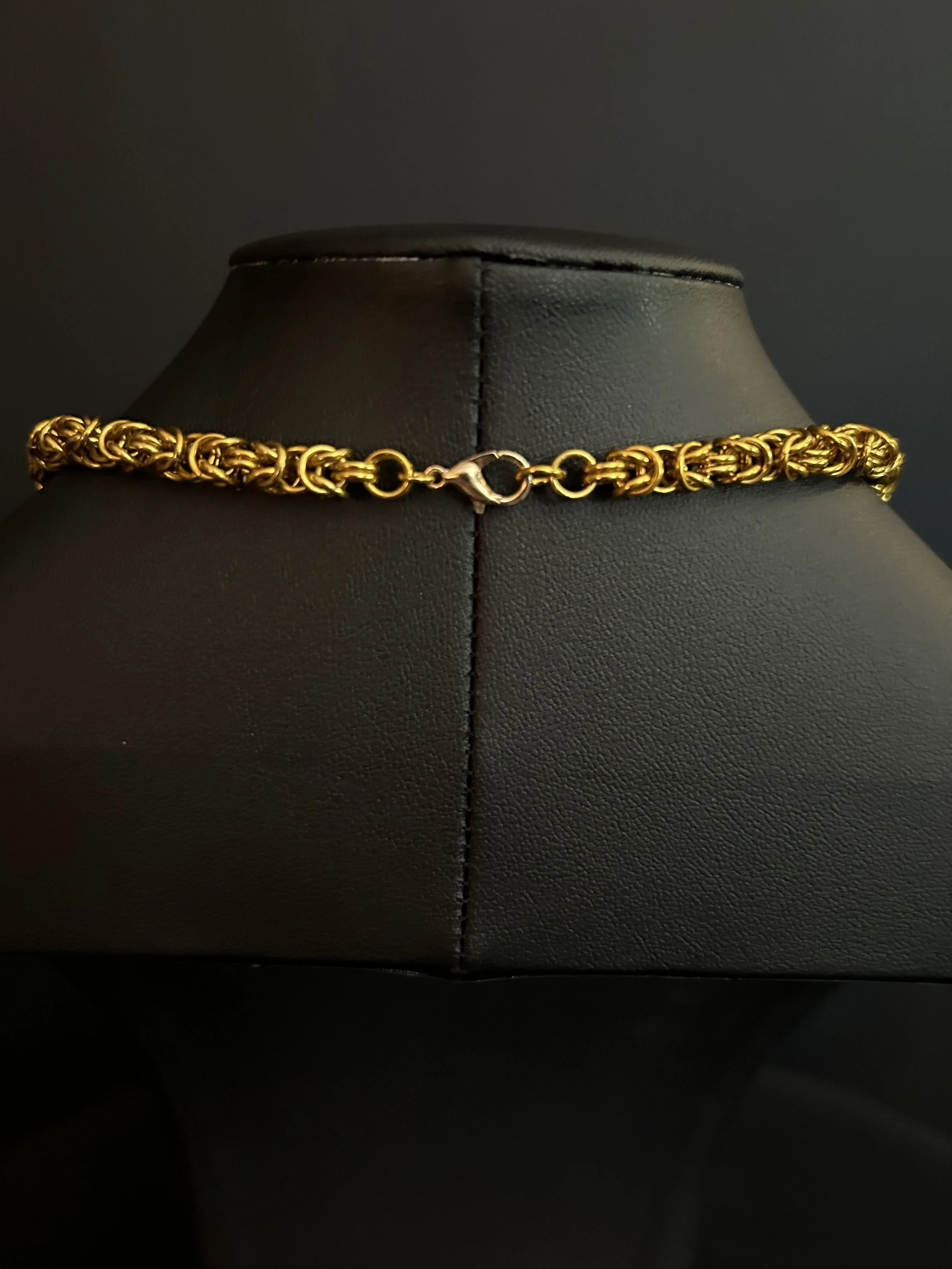Clasp of hand‑woven gold‑tone chainmaille necklace with seven 8mm strawberry quartz beads and gold‑plated spacers,