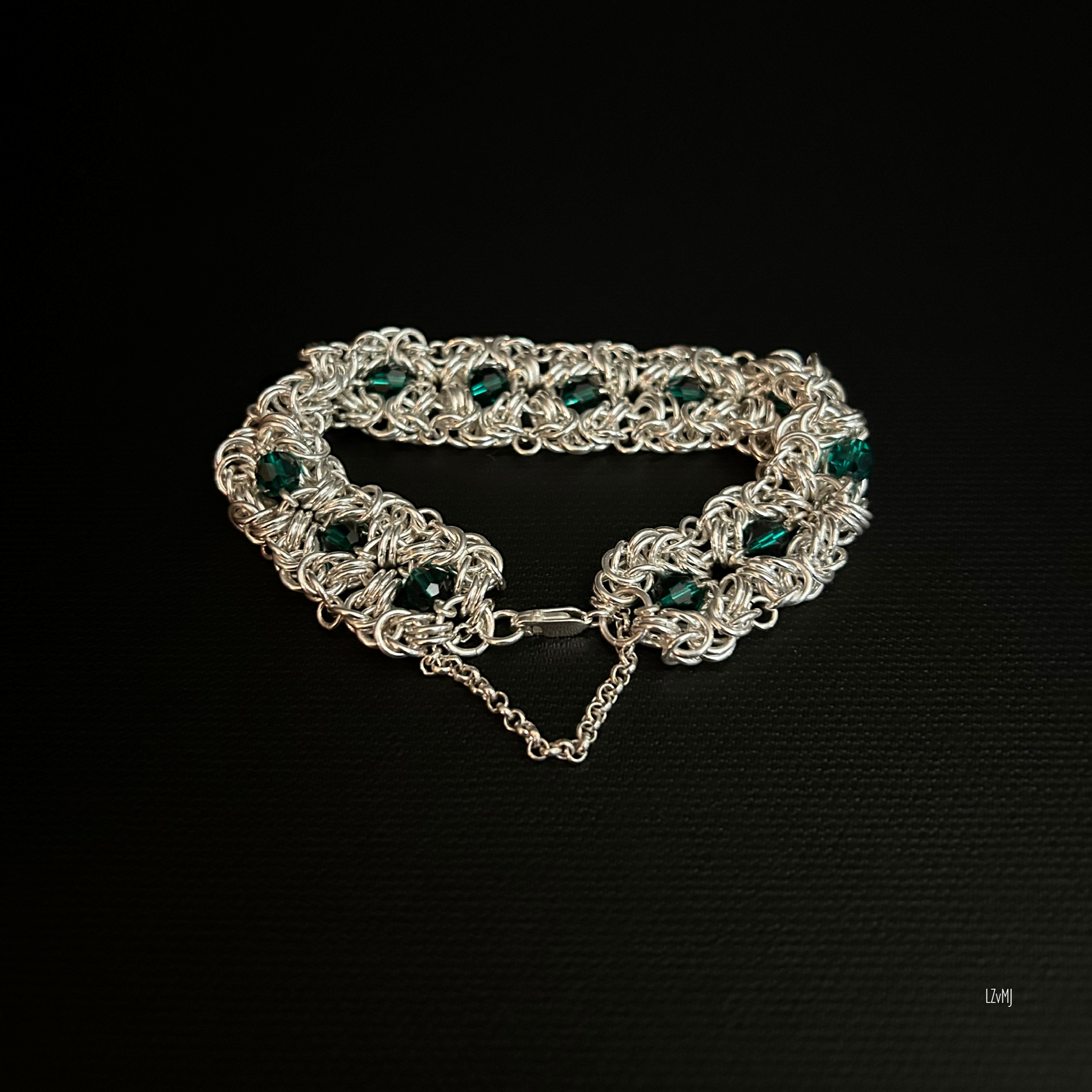 Forestlight Rosette bracelet laid flat, showing sterling rosettes and green crystals