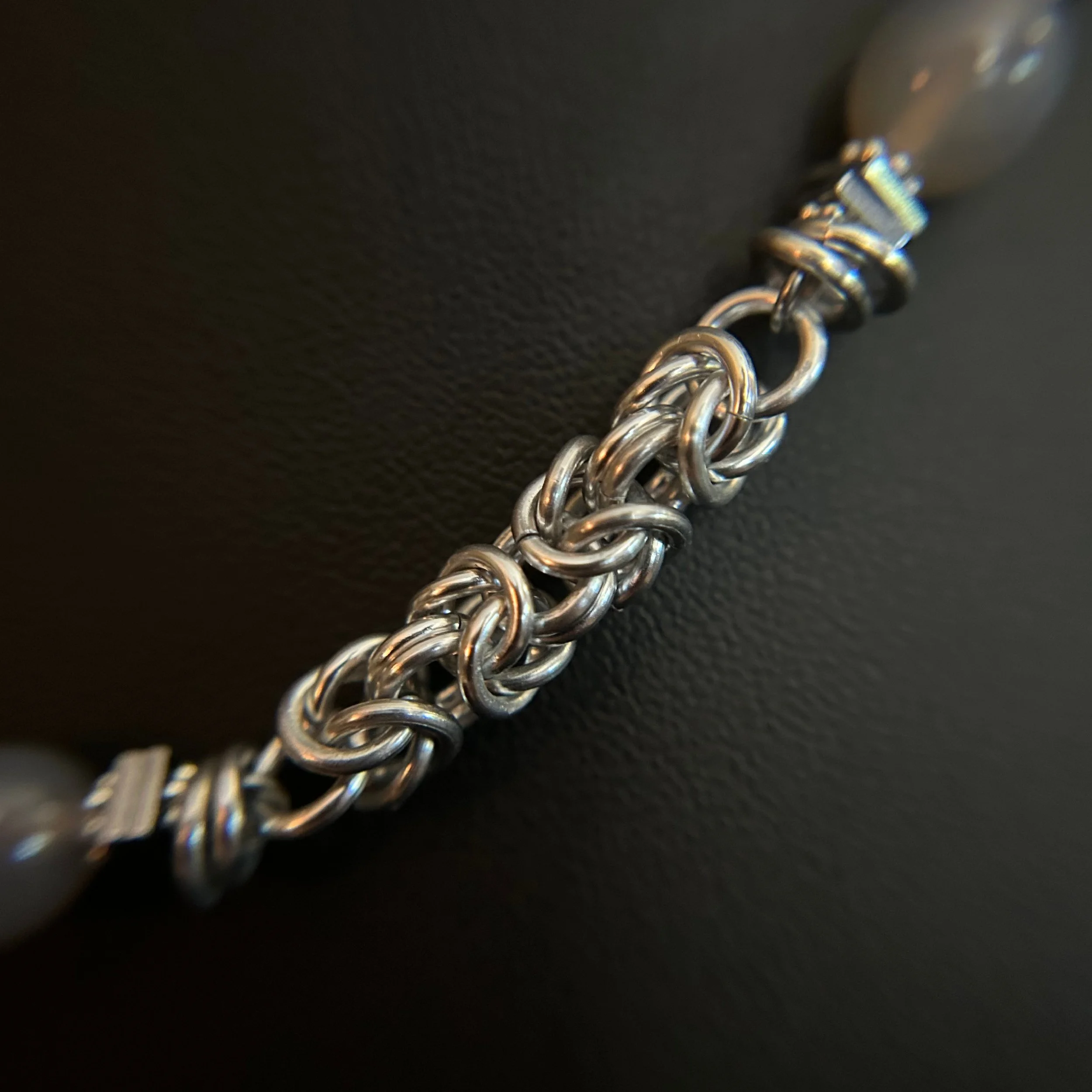 Close-up of the Moonlit Harbor necklace showing the intricate silver chainmaille weave