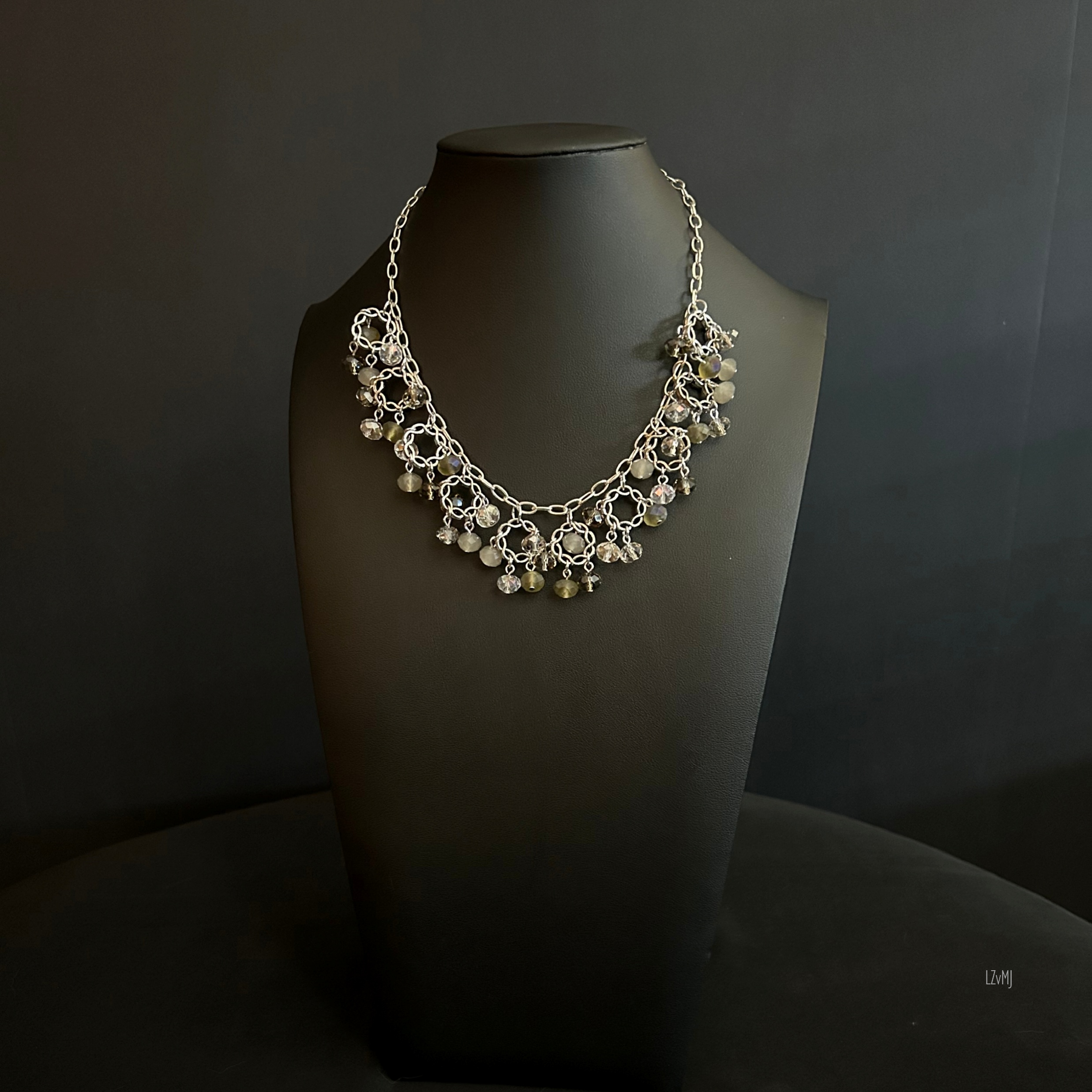 Crystal Orbit necklace displayed on a black bust, with alternating silver chainmaille links and glossy black beads