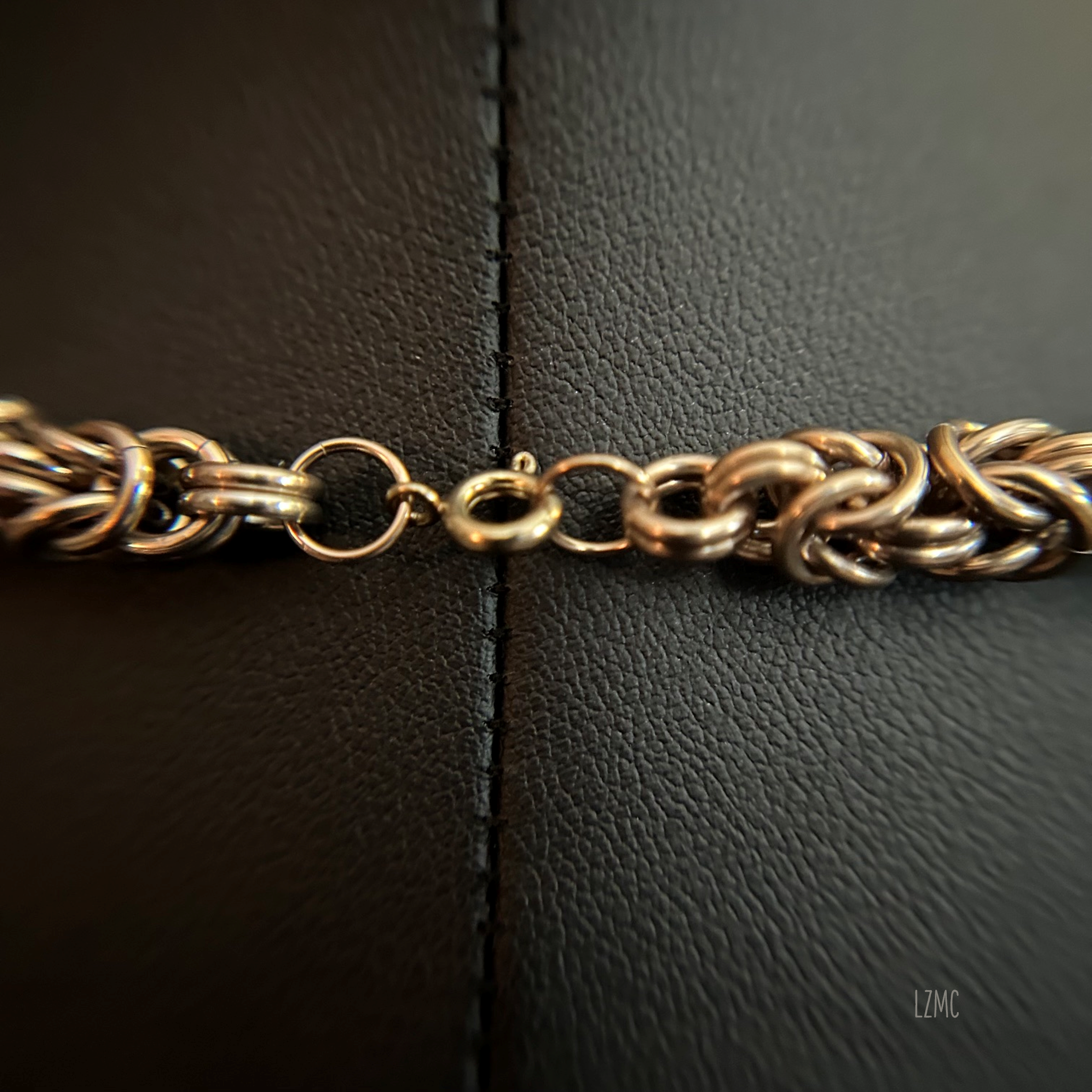lose‑up of the spring‑ring clasp and chainmaille connection, showing the clean finish and attachment point of the necklace.