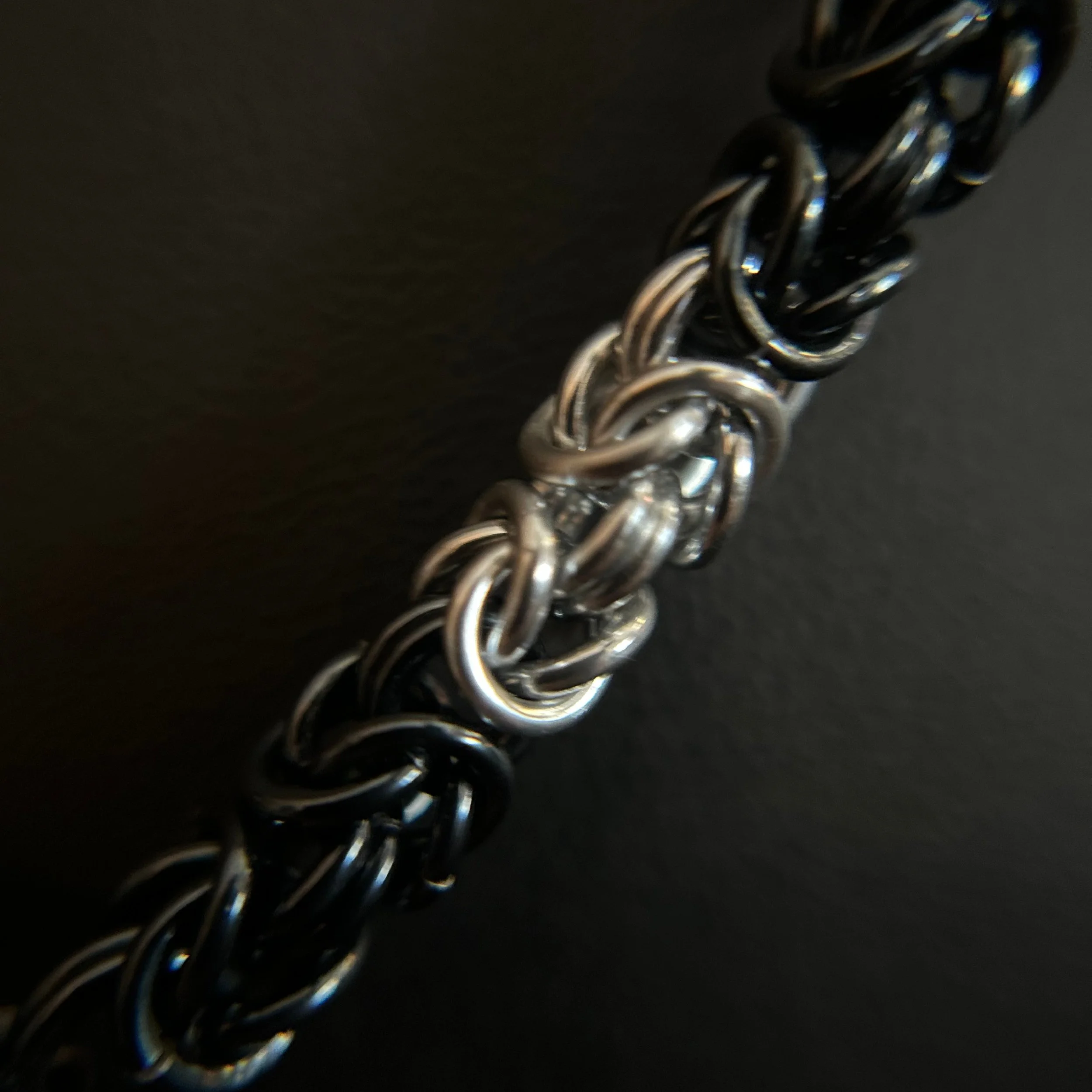 “Close-up of the Black Ice and silver chainmaille weave.”