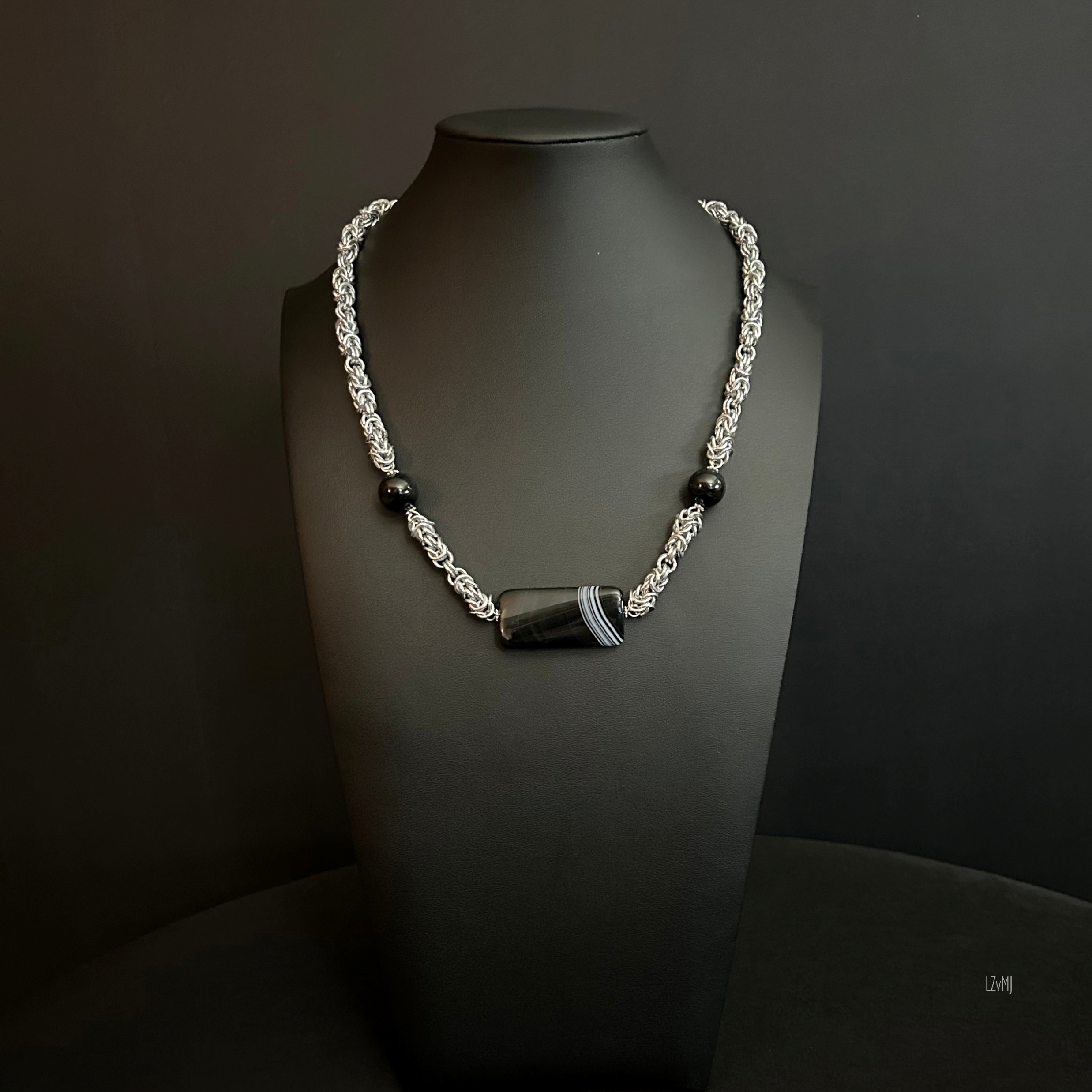 “Full view of the aluminum chain necklace with sardonyx focal and tourmaline beads.”