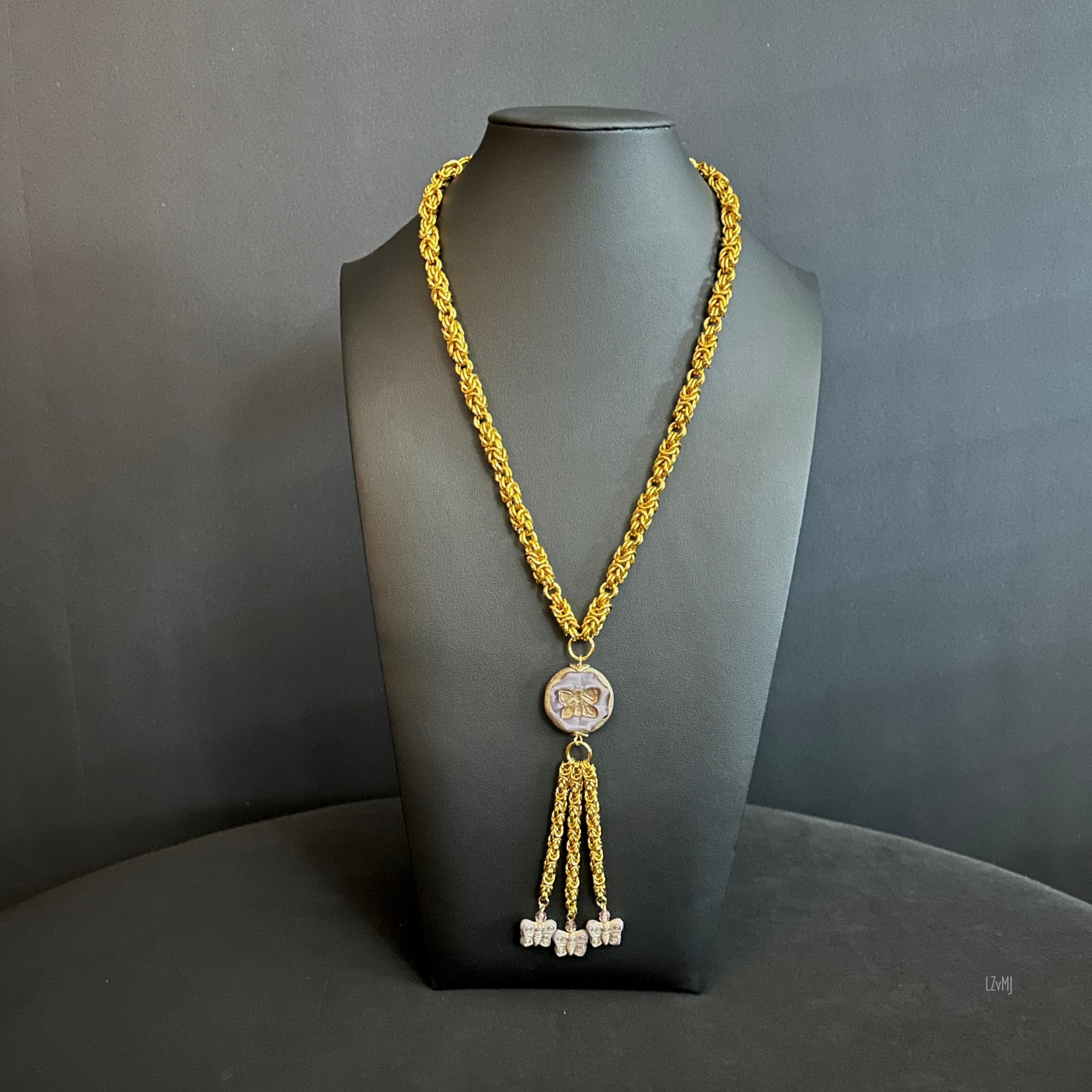 “Full view of the gold‑tone chainmaille necklace with butterfly focal and tassel.”
