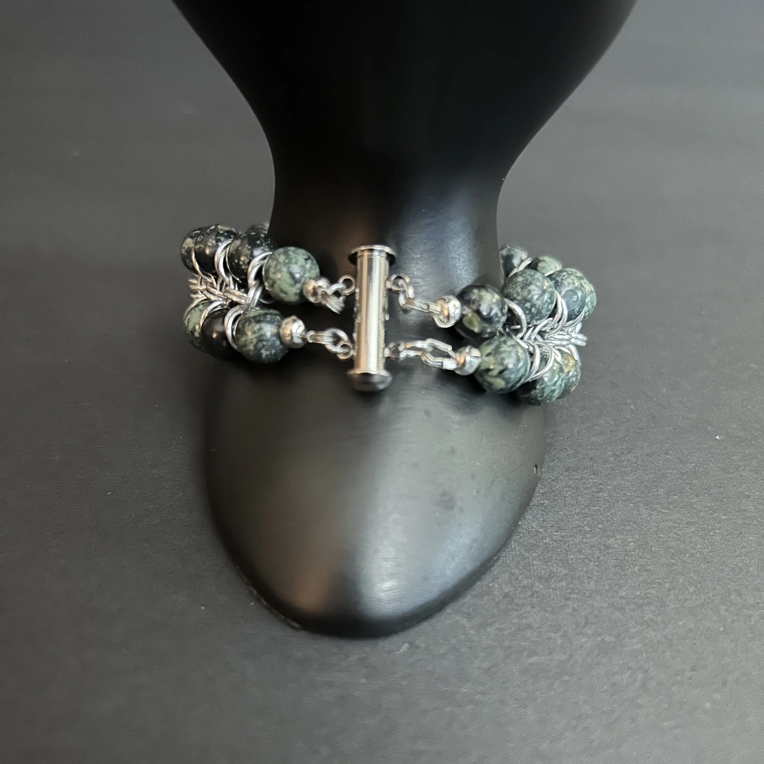 Closeup of the stainless slide‑lock clasp and double‑strand structure of the Kambaba Jasper and aluminum bracelet.