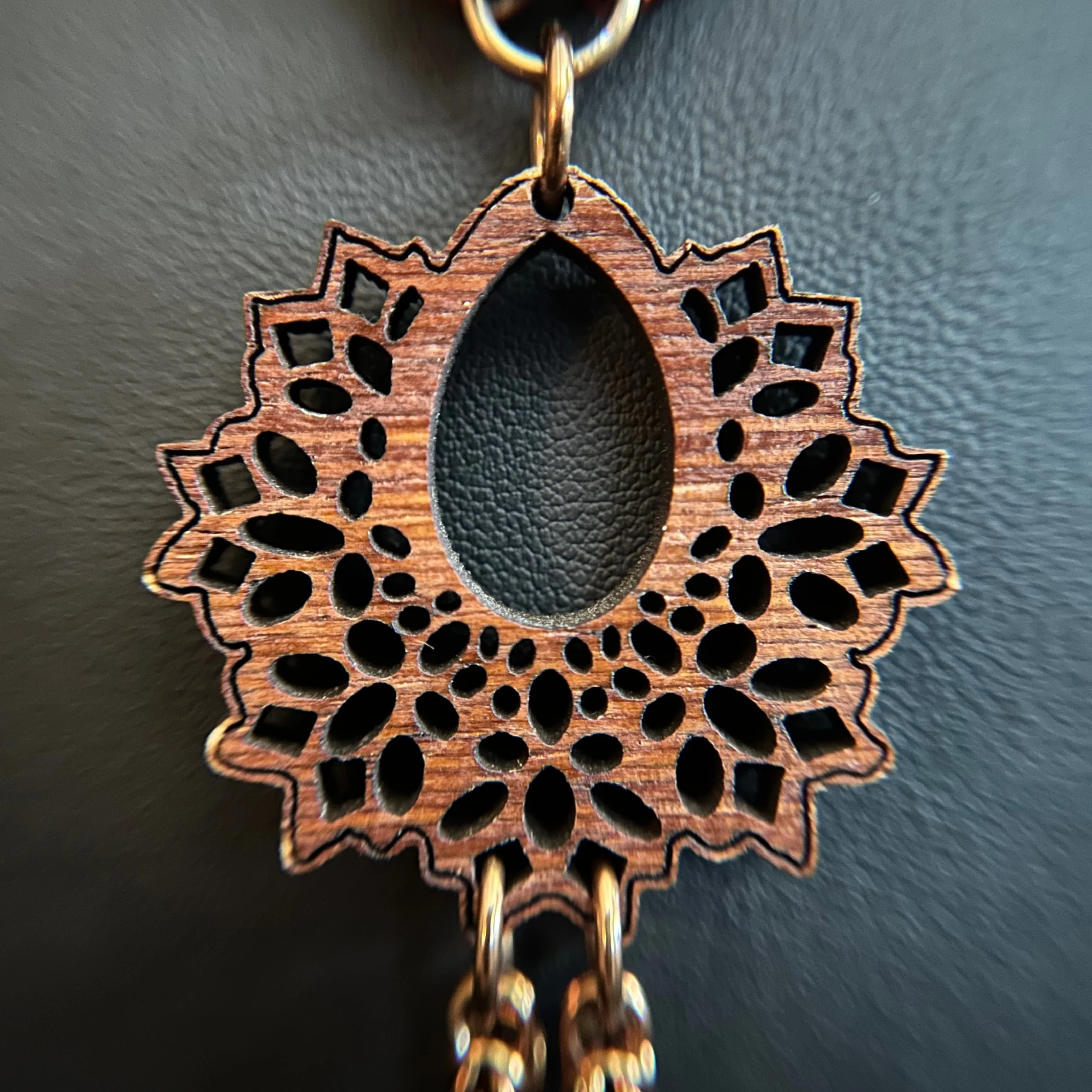 “Detail of the carved wood focal showing its texture and warm tone.”