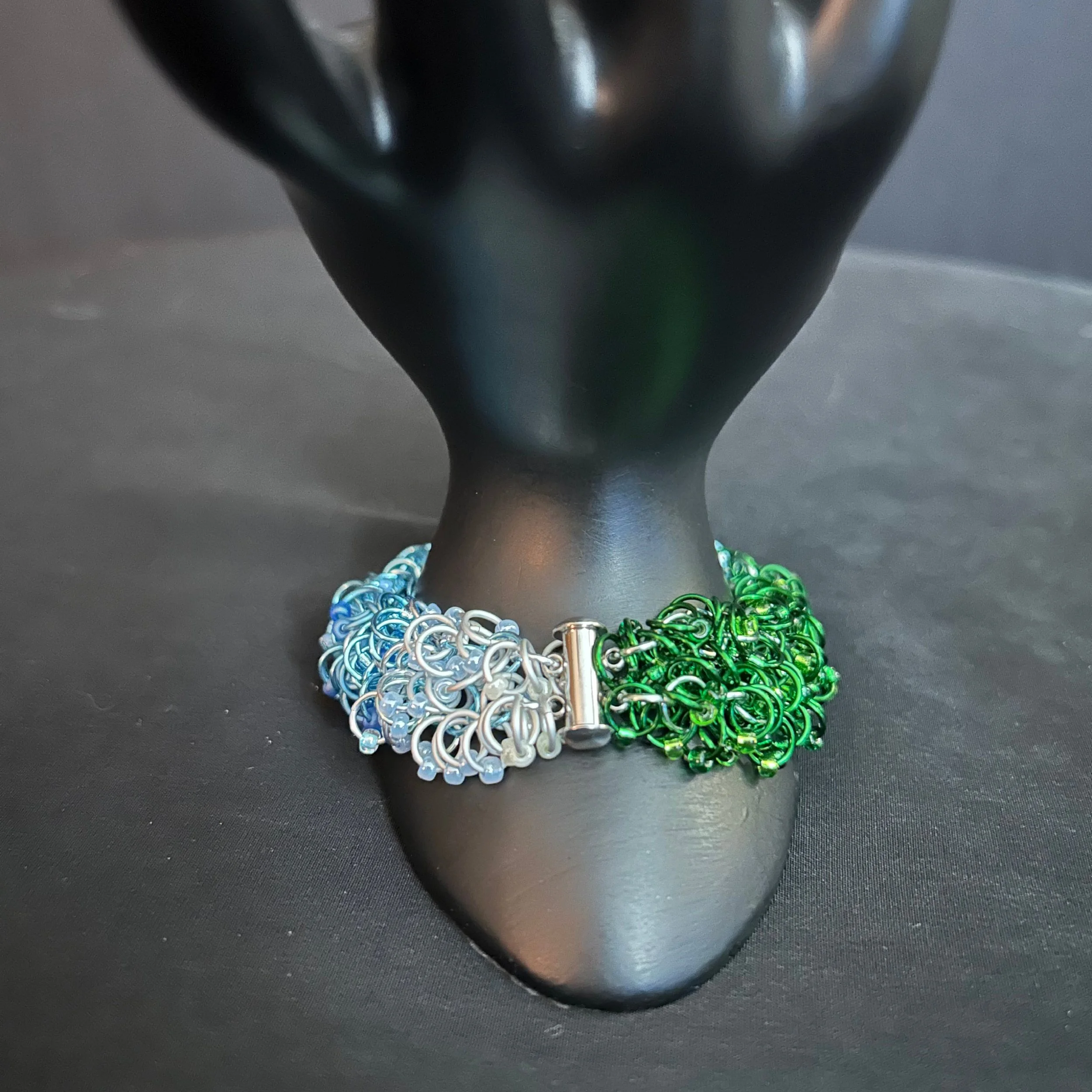 “Bracelet on hand prop with the slide‑lock clasp and safety chain clearly visible.”