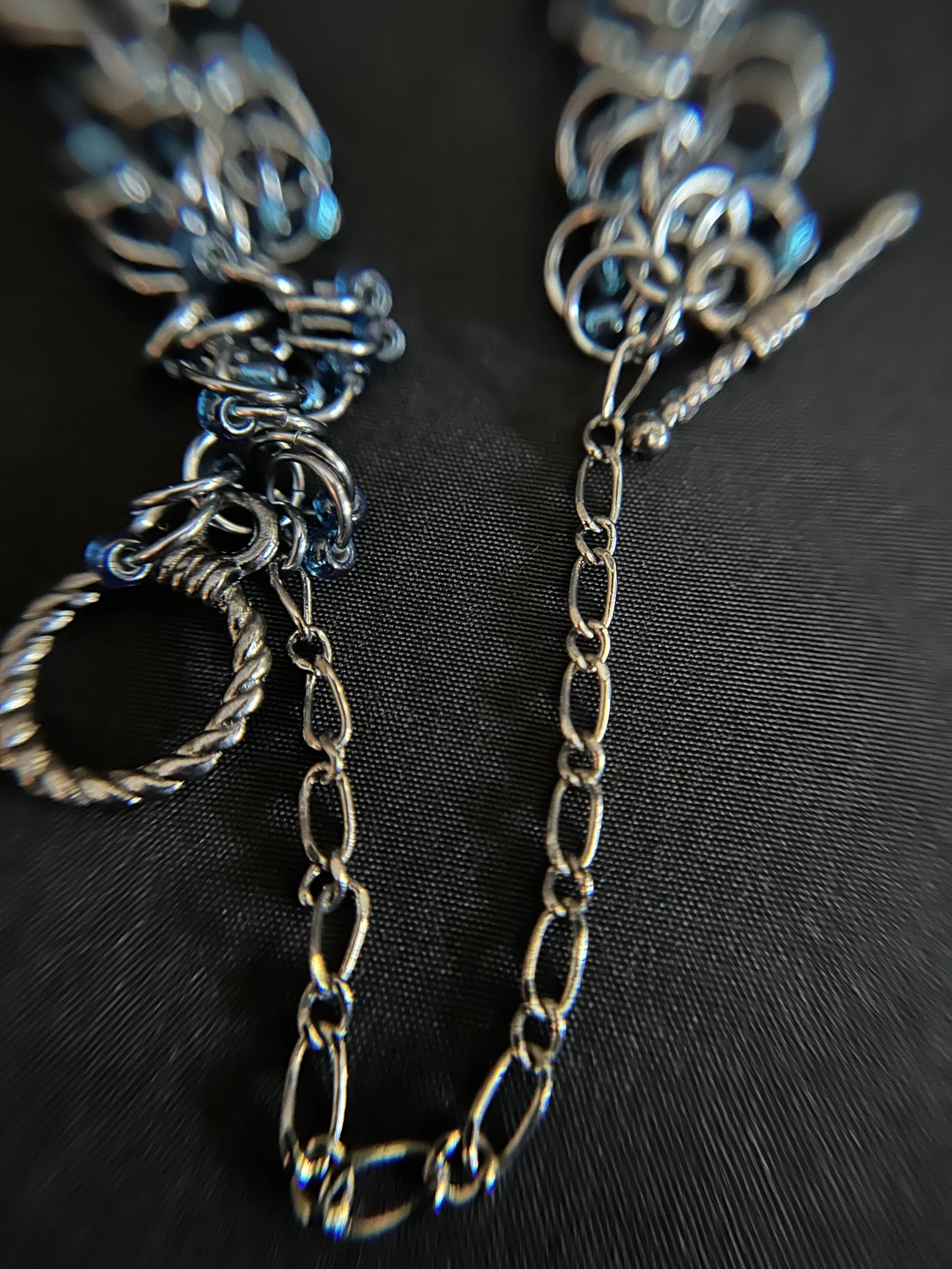 Gunmetal toggle clasp and safety chain of the Midnight River bracelet, shown with the Black Ice rings for scale and detail