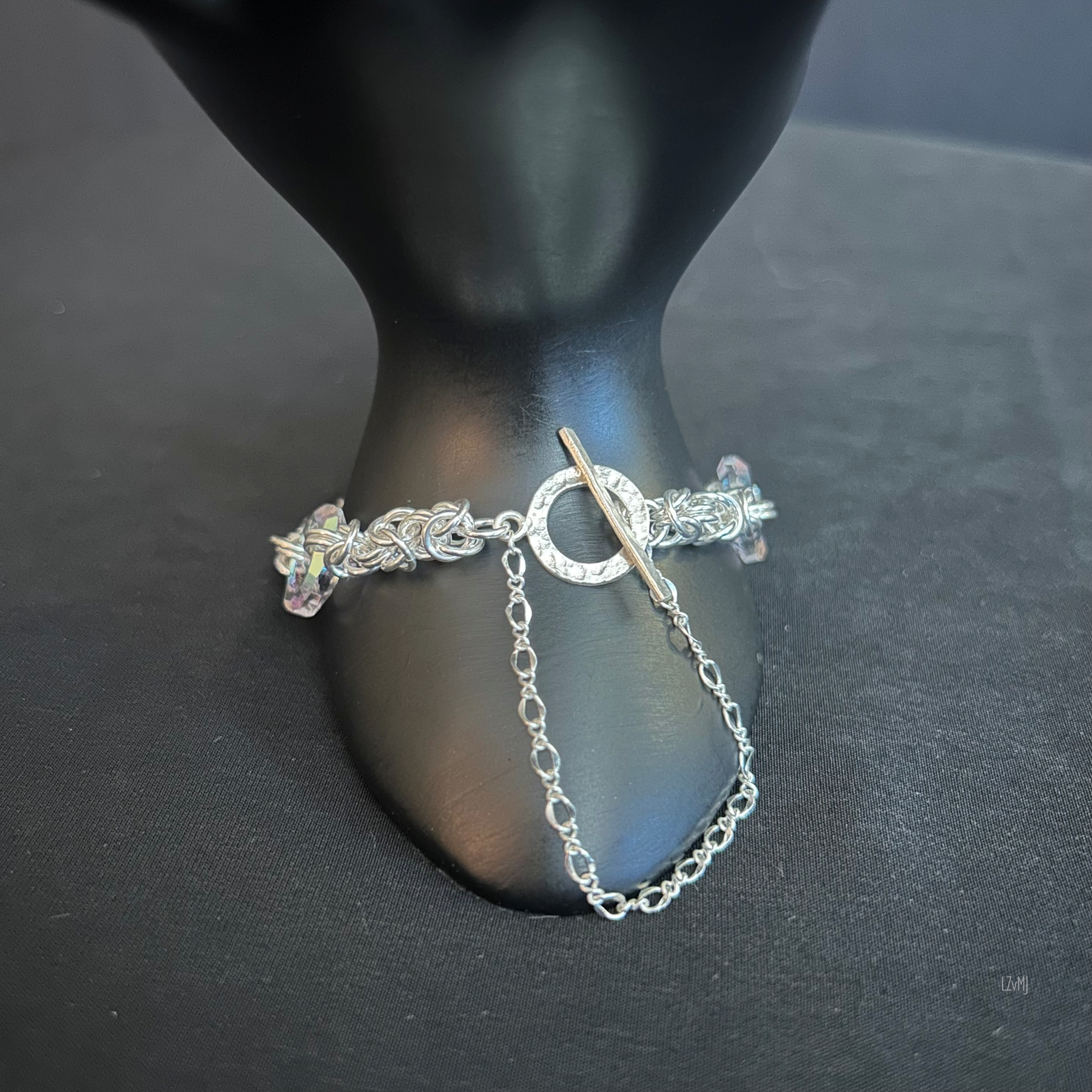 lose-up of the Sterling toggle clasp and Figaro safety chain on a Byzantine chainmaille bracelet with Swarovski donuts.