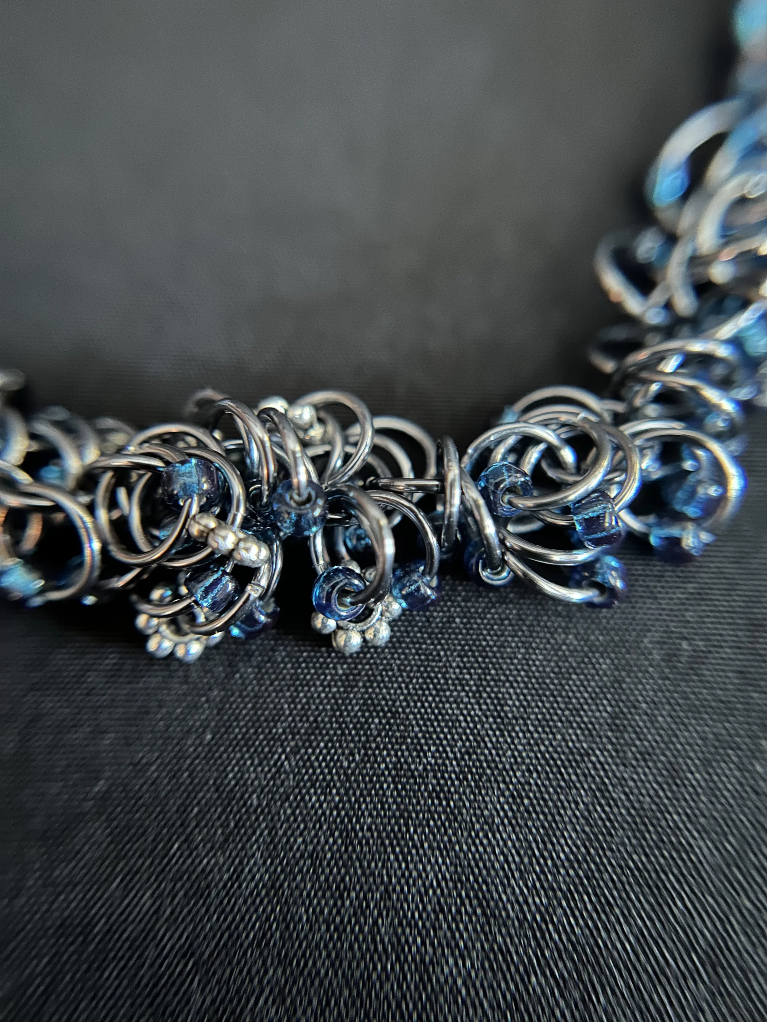 Close‑up of the Midnight River bracelet’s shaggy‑loop weave, showing the interlinked Black Ice rings and midnight blue Miyuki beads