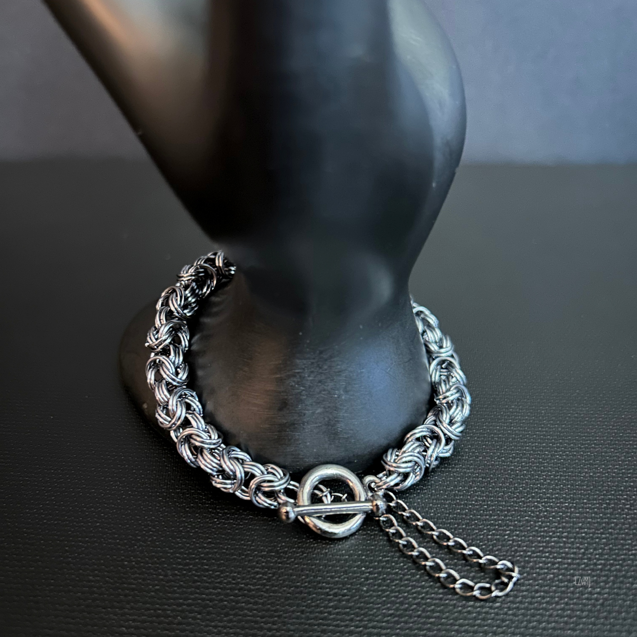 “Close-up of the toggle clasp, leaf charm, and moonstone bead resting on the display prop.”