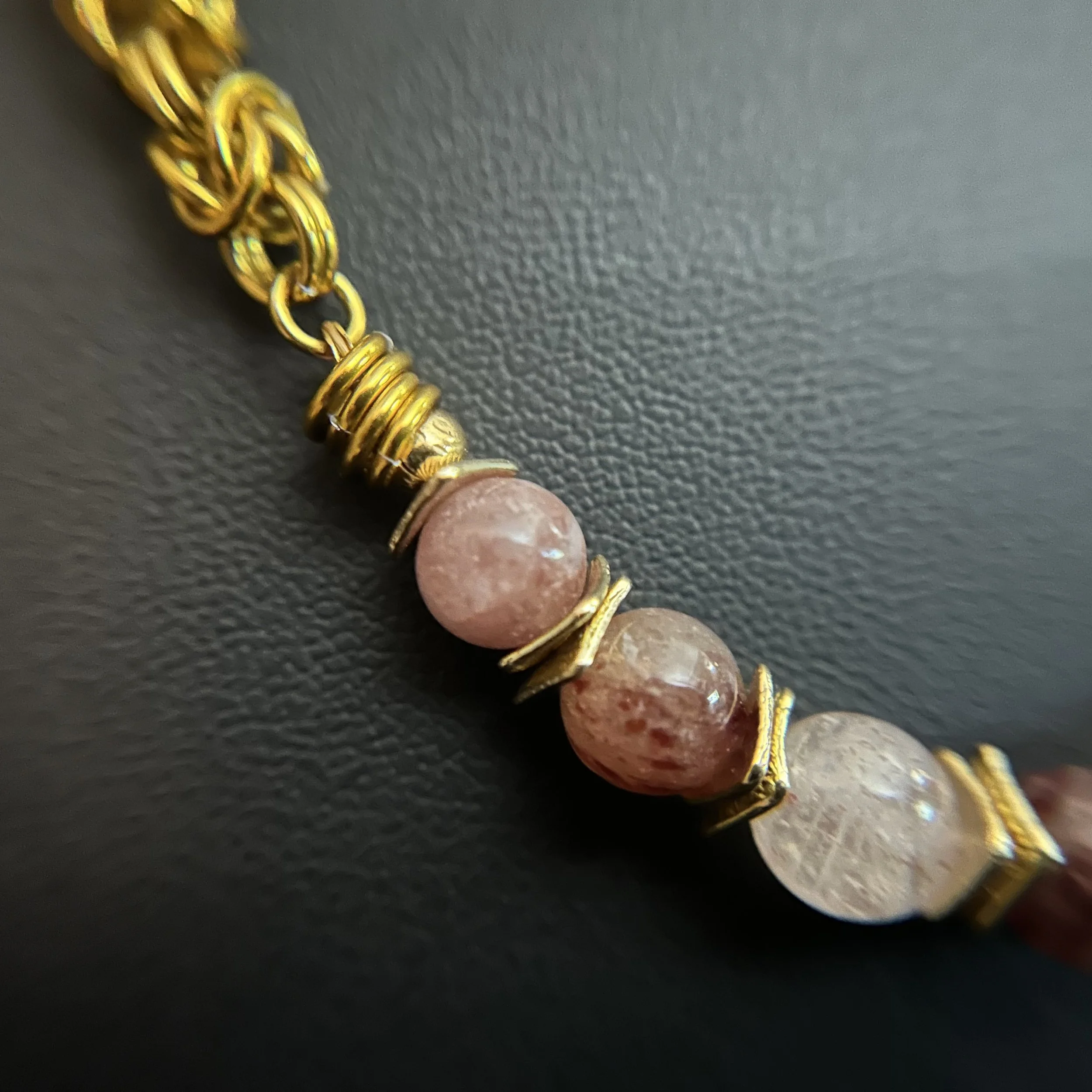 “Close-up of the strawberry quartz stones with gold‑plated spacer accents.”