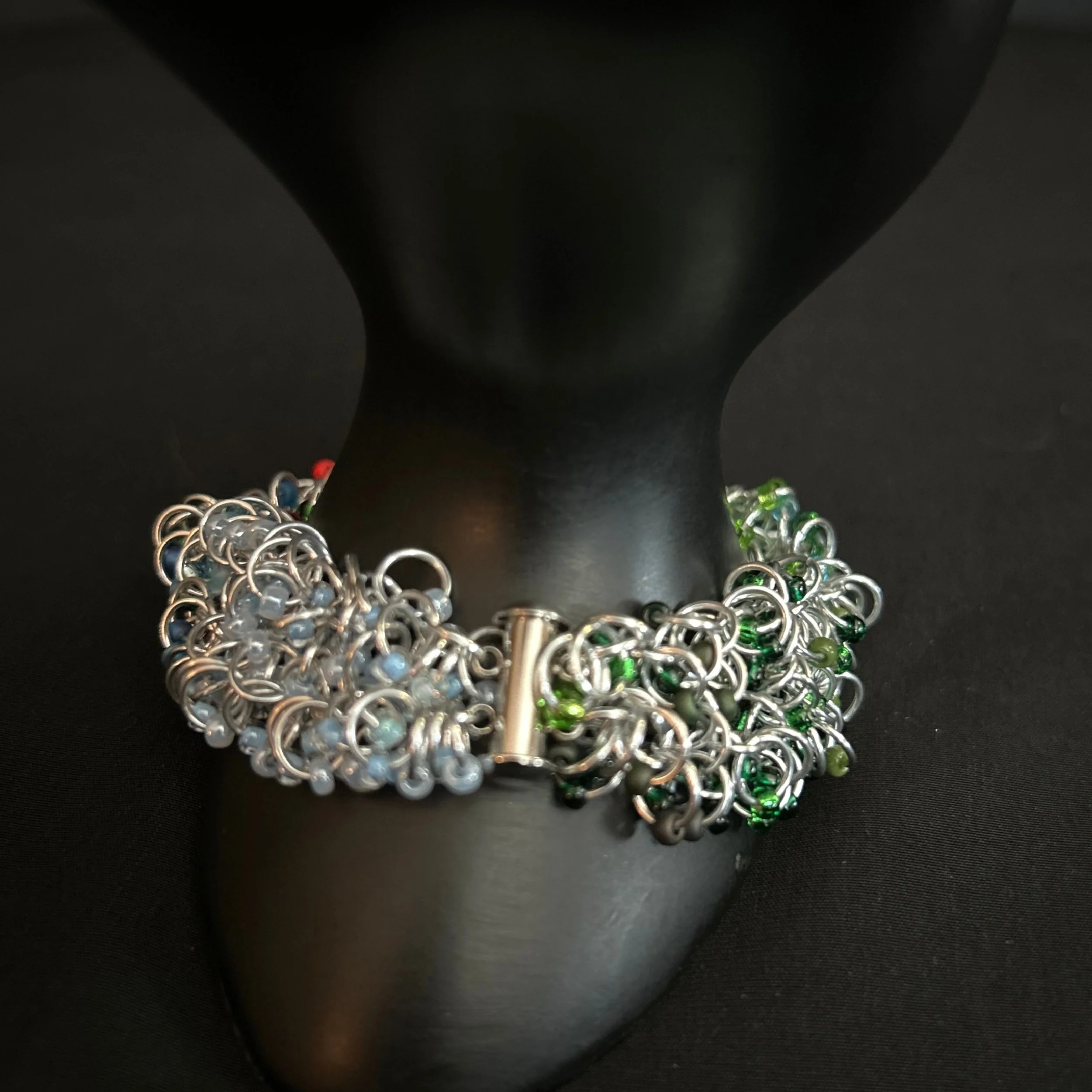 “Bracelet on display prop with the slide‑lock clasp and safety chain visible.”