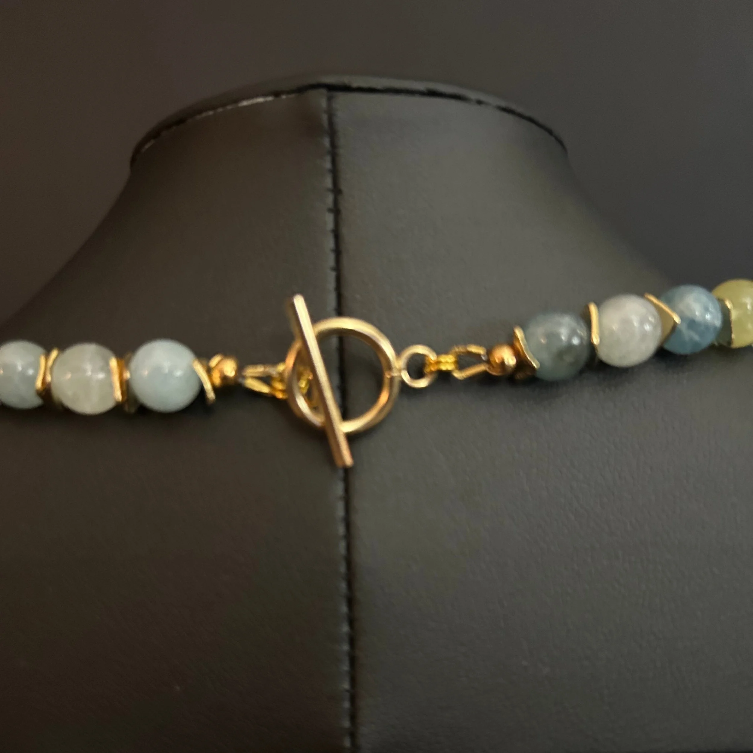“Close-up of the gold‑tone toggle clasp and connecting aluminum rings.”