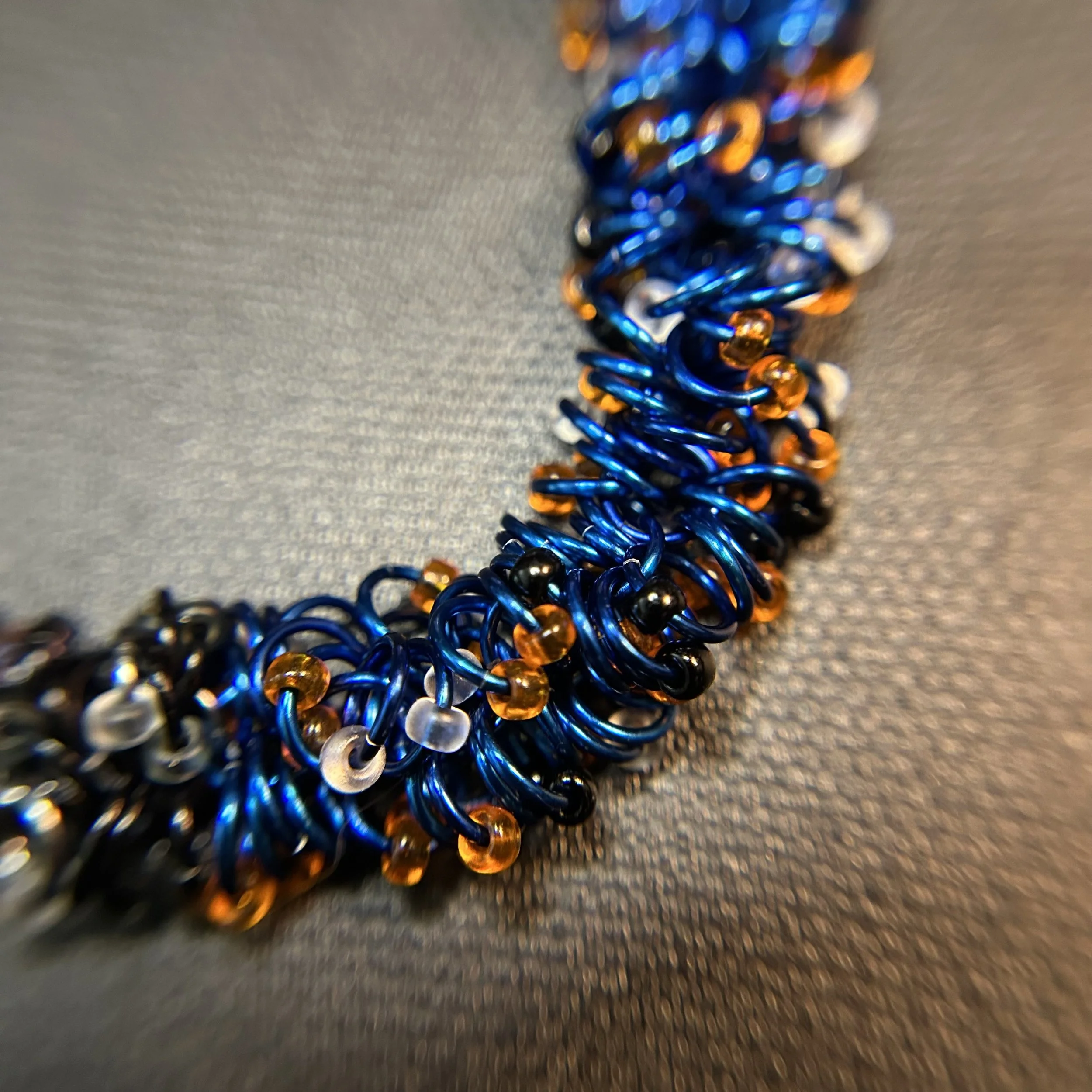 Closeup of the bracelet’s shaggy‑loop weave, showing the six‑shag structure and the transition between black, Black Ice, and royal blue rings.