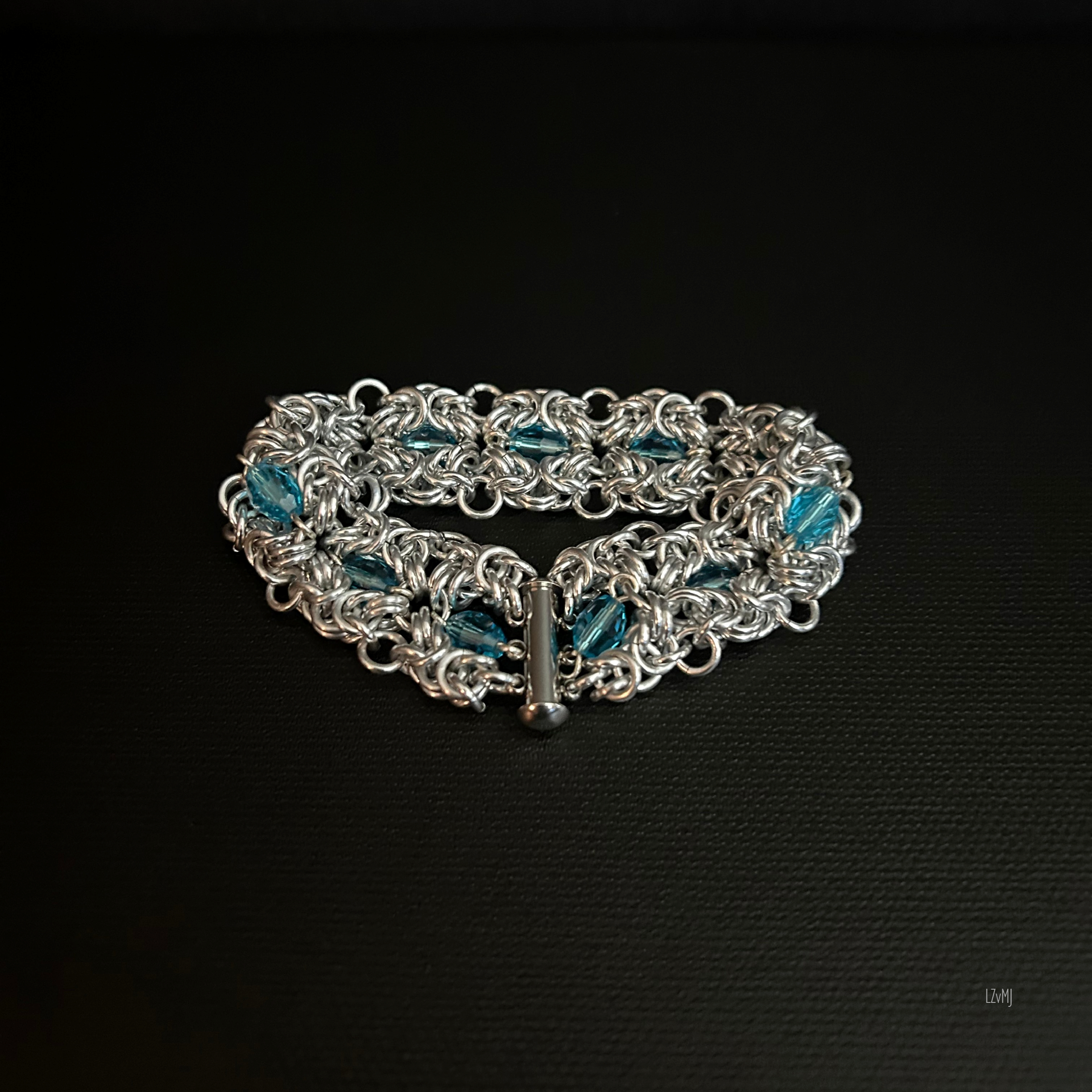 Detail of the Turquoiseberry Byzantine bracelet with bright aluminum rings and turquoise crystals set into the weave