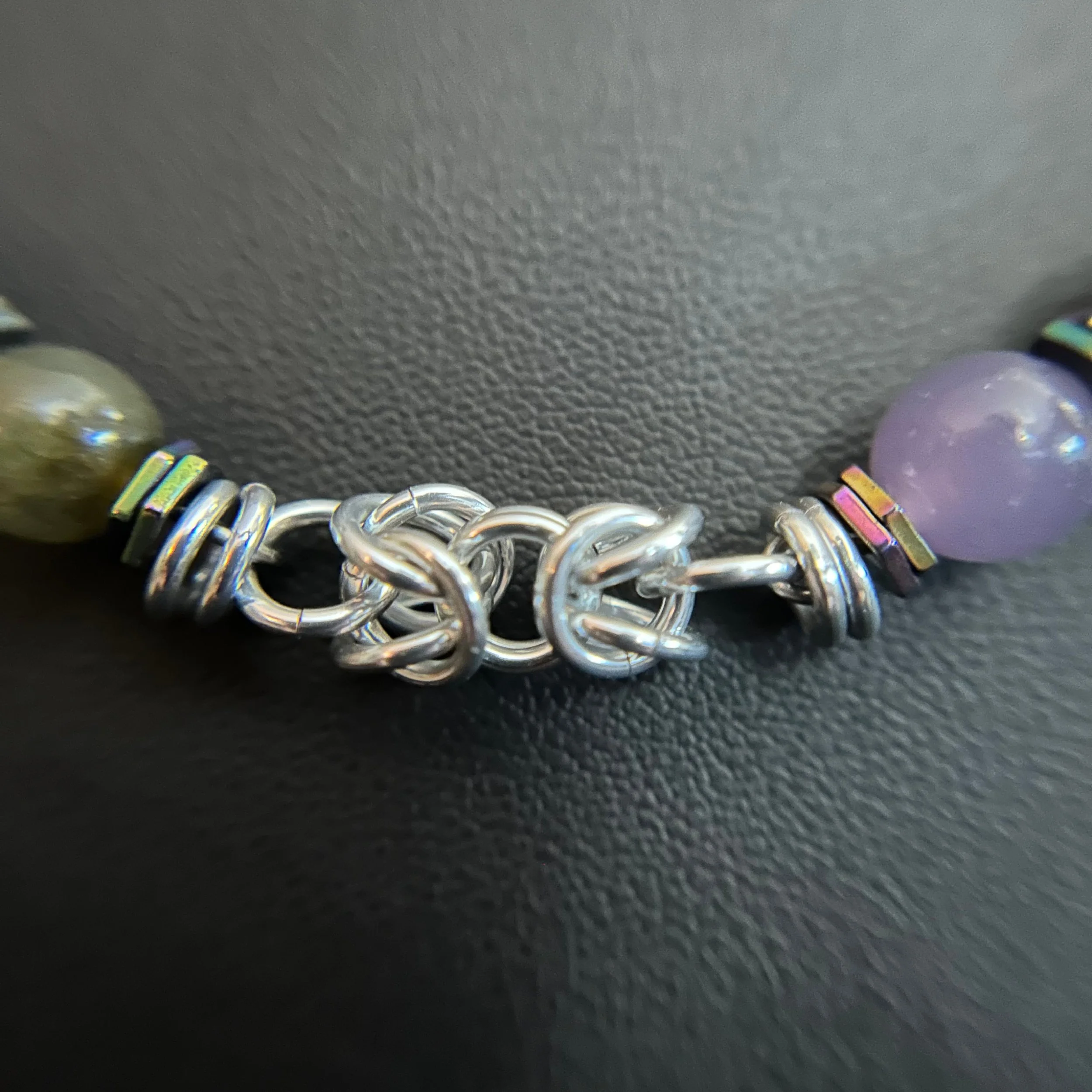 “Detail of the silver chainmaille weave between the gemstone sections.”