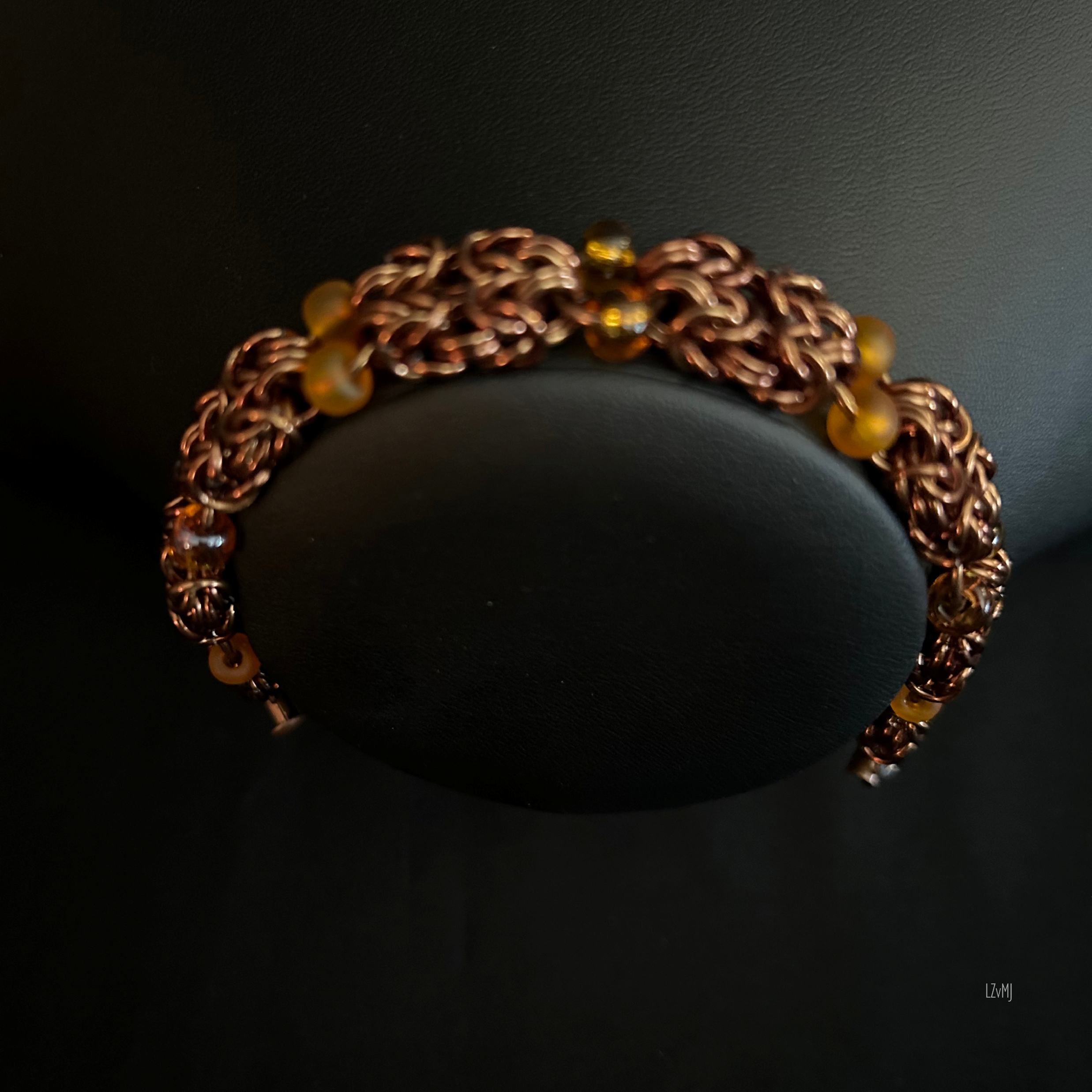 “Bronze Amberlight bracelet displayed on a black jewelry bust showing warm bronze tones.”