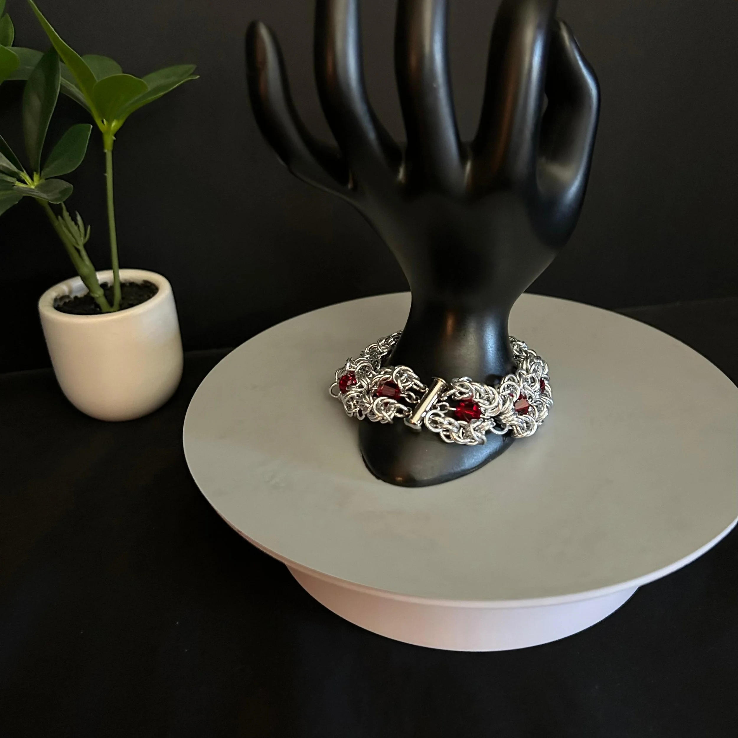 Ruby Frost chainmaille bracelet showing clasp and red crystal accents on display hand