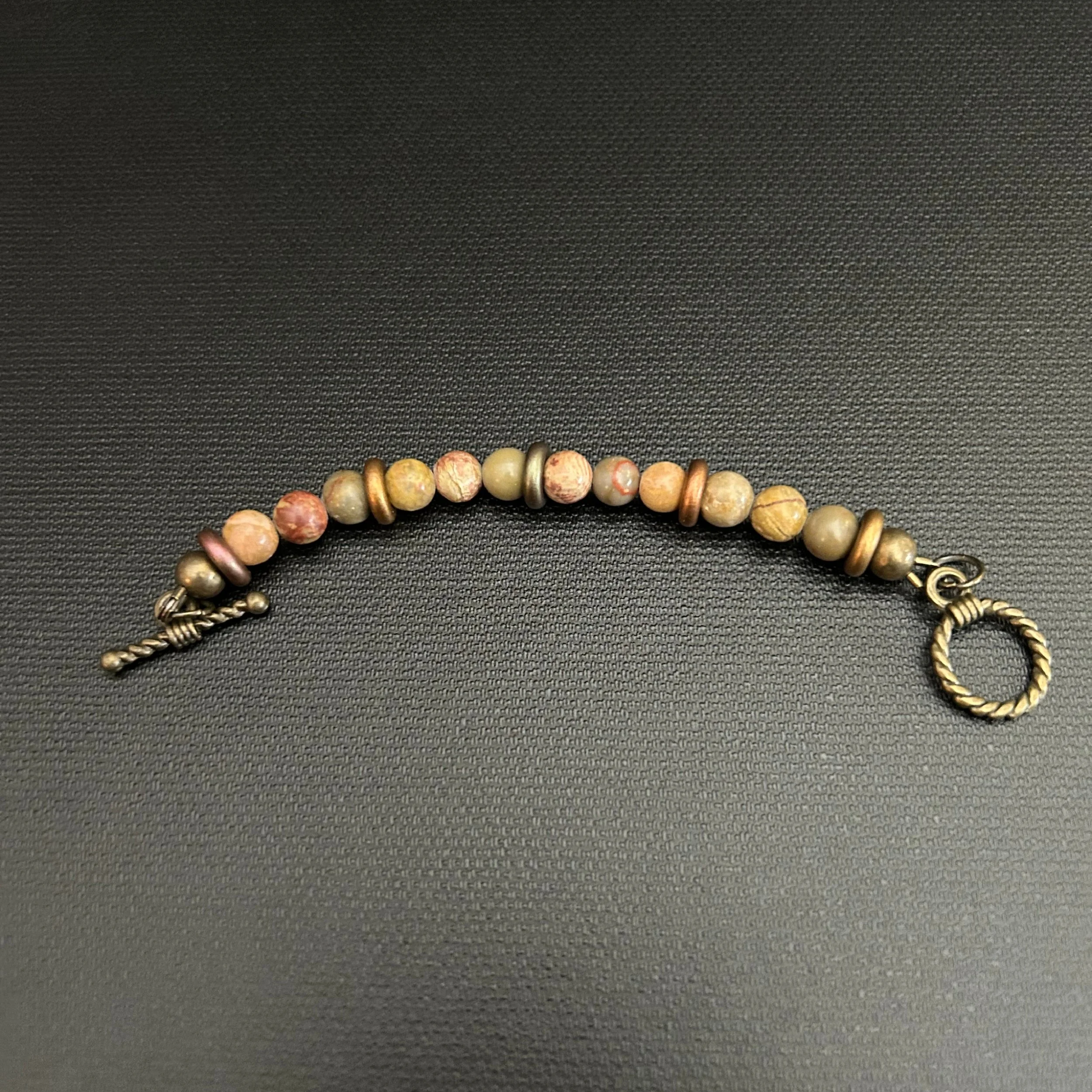 “Close-up of the matching jasper and rondelle extender with bronze toggle clasp.”